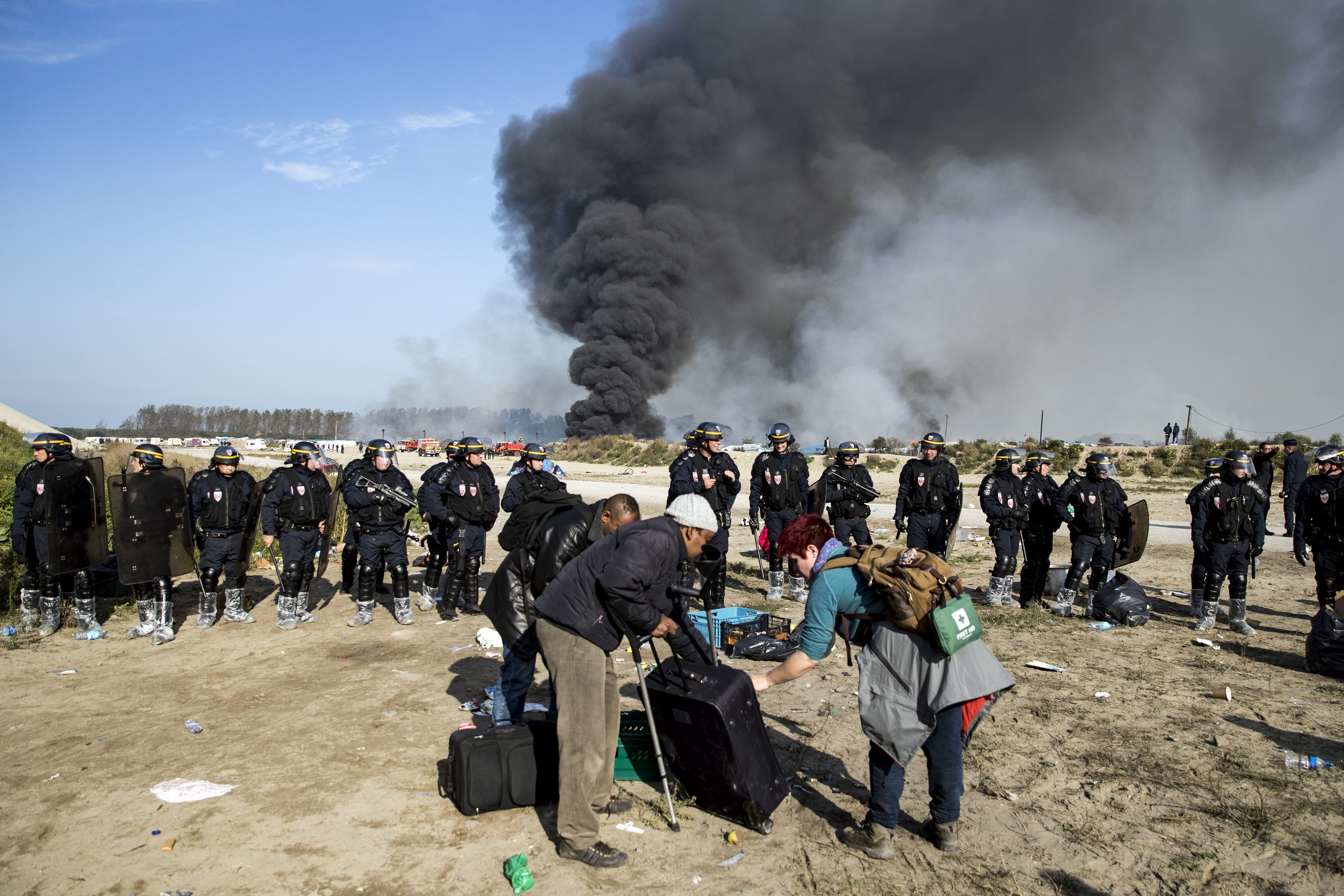 Ewakuacja migrantów z obozowiska Calais we Francji po podpaleniu. fot. EPA/ETIENNE LAURENT 