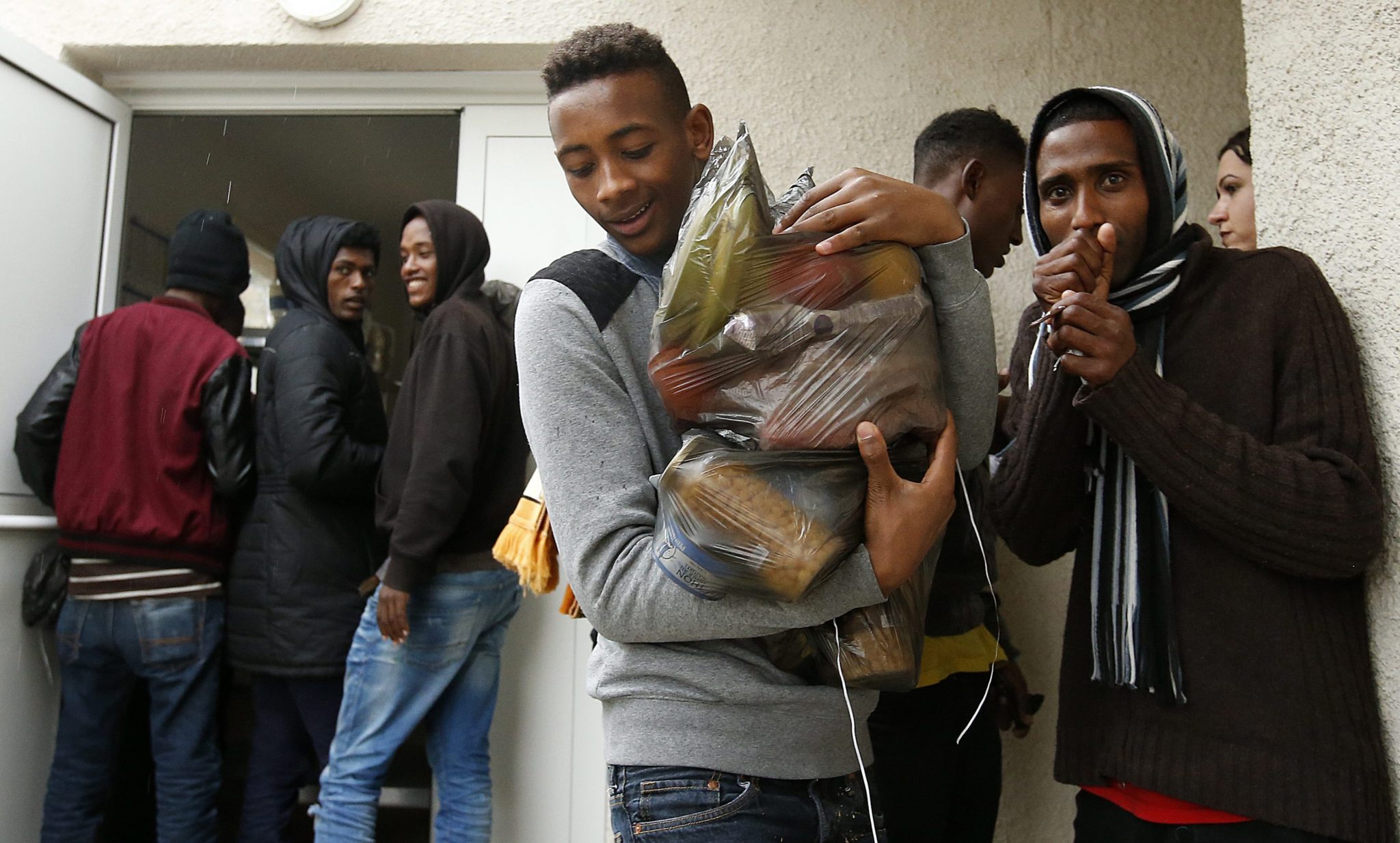 Młodzi migranci z Calais, po wyprowadzeniu się dostają prowiant. Fot. EPA/GUILLAUME HORCAJUELO 