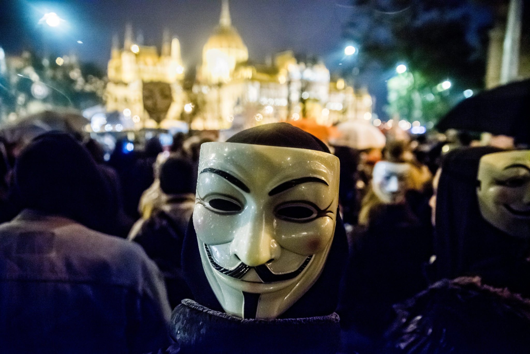 Protestujący zakładają maski Guy'a Fawkes'a. Marsz Miliona Masek, Budapeszt, Węgry, 5 listopada 2016.