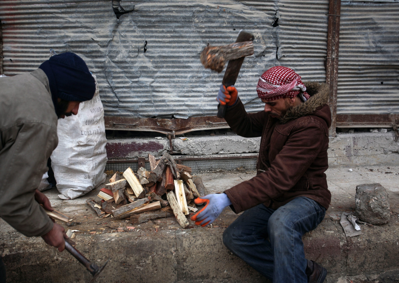 Mężczyzna rozpala ognisko w Dumie na przedmieściach Damaszku, Syria.