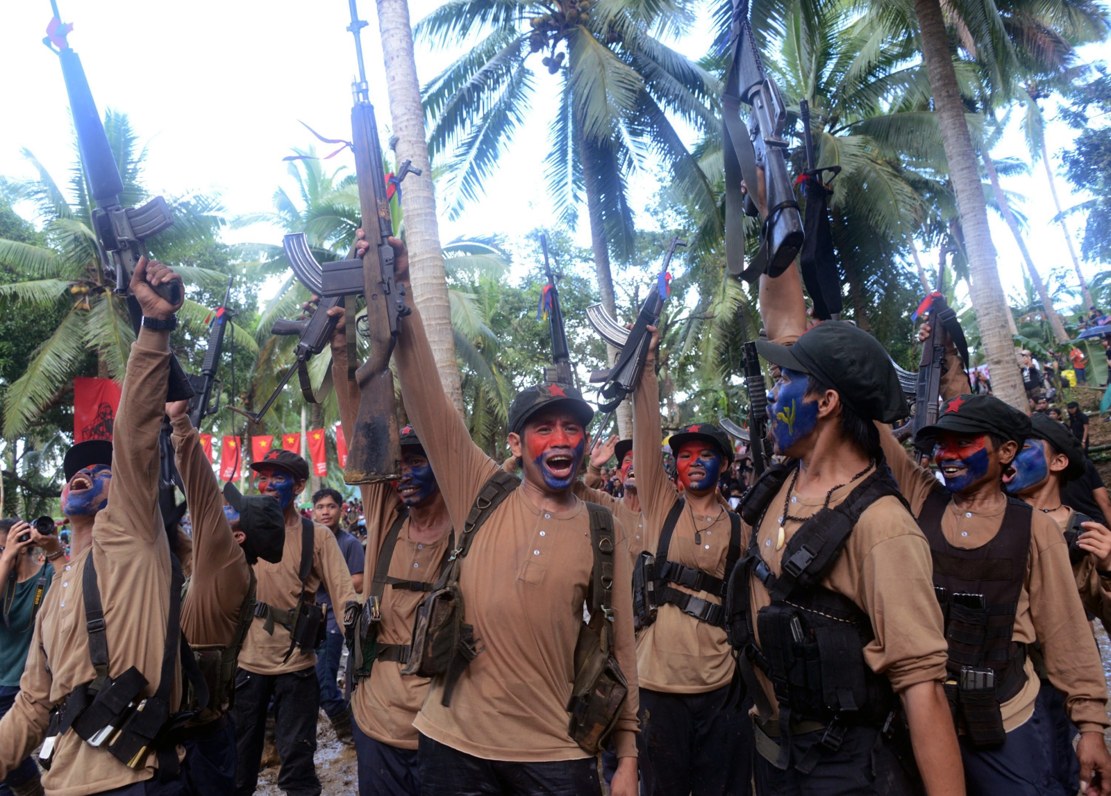 Członkowie filipińskiej Nowej Armii Ludowej wykrzykujący slogany komunistyczne podczas rocznicy istnienia grupy w góach Sierra Madre na Filipinach. Fot. PAP/EPA/PAT ROQUE 
