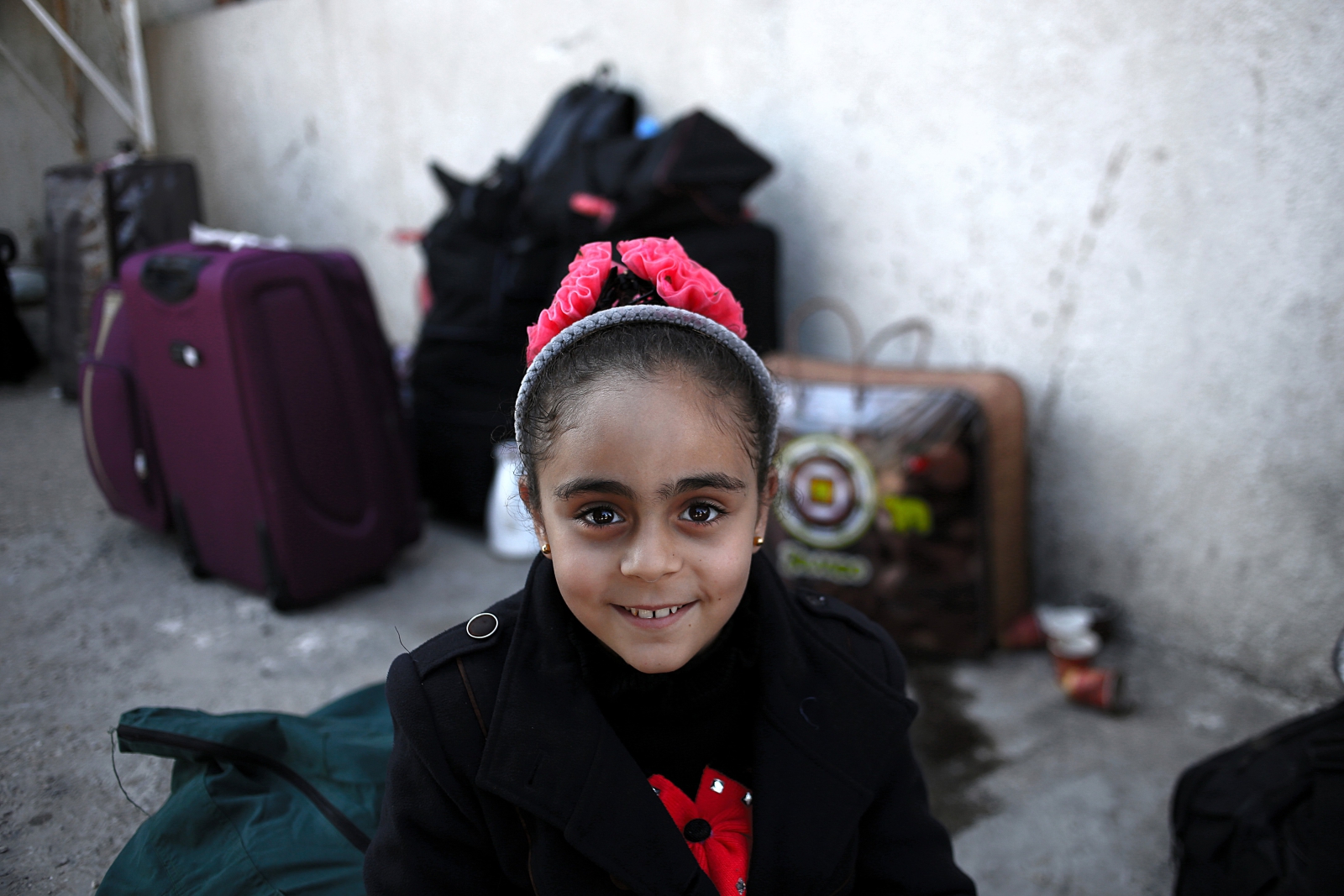 Palestyńska dziewczynka czeka wraz z rodziną na przekroczenie granicy z Egiptem.