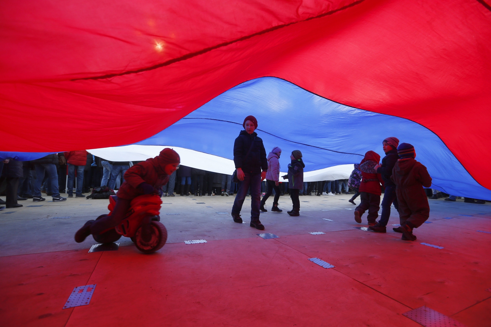 Dzieci bawią się pod ogromną rosyjską flagą w trzecią rocznicę aneksji Krymu.