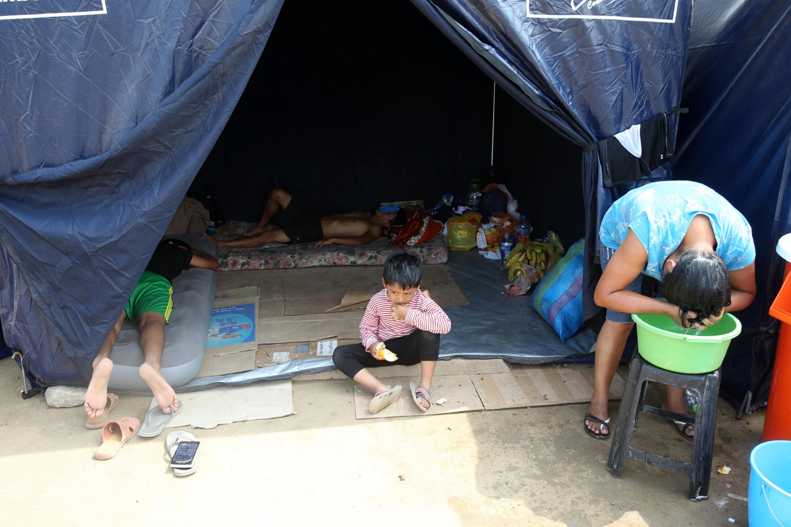 Rodzina odpoczywa w namiocie dla ofiar wielkich powodzi w Limie, Peru.