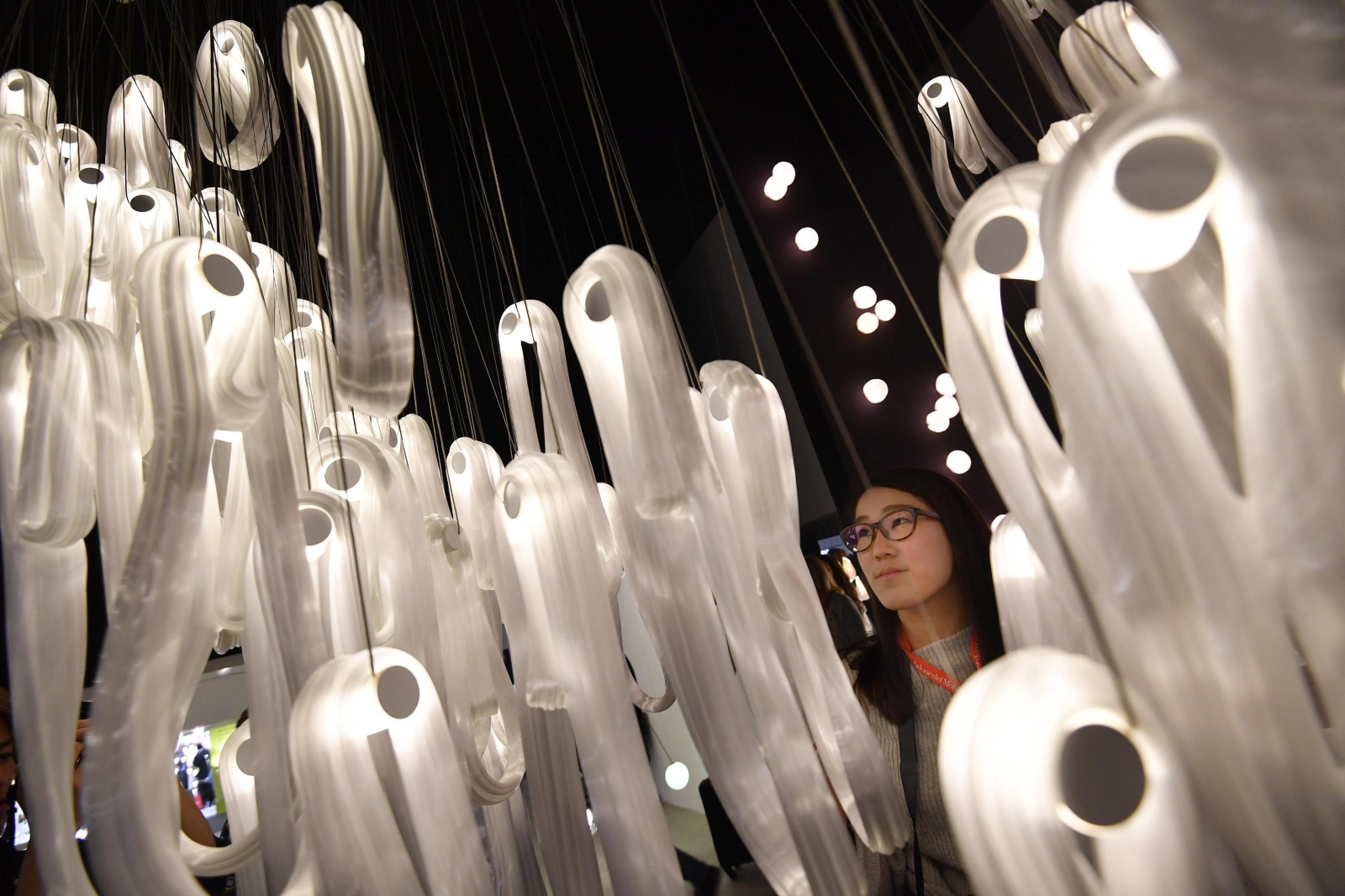 Ludzie oglądają kolekcję lamp na wystawie mebli w Rho-Pero, w pobliżu Milanu, Włochy.