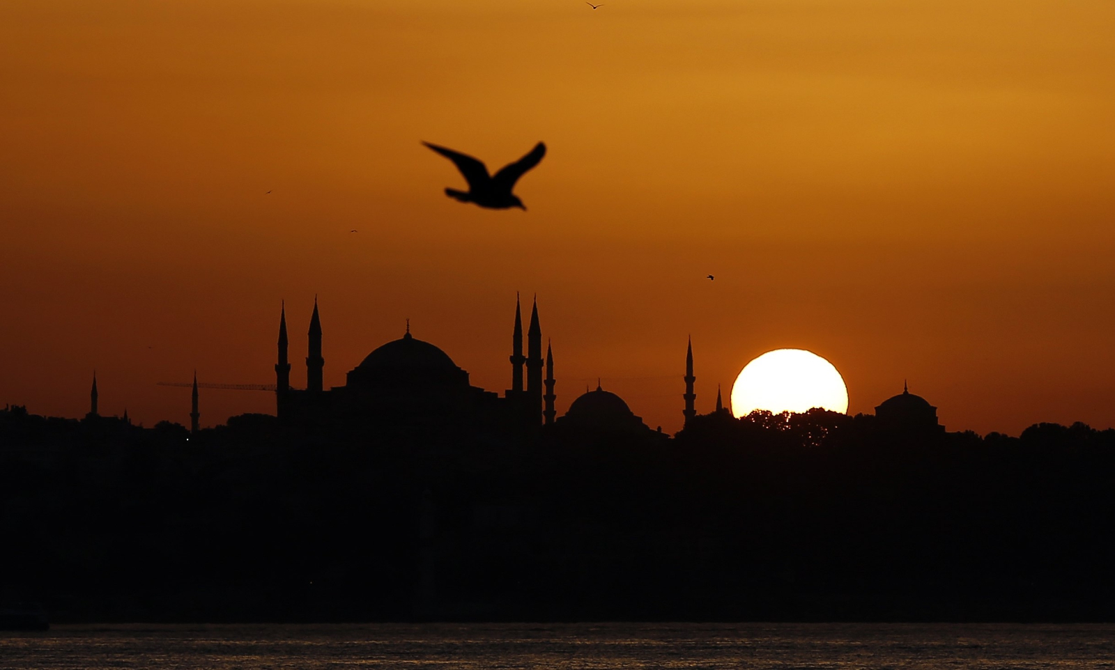 Słońce zachodzi nad bazyliką Hagia Sophia w Istambule, Turcja.