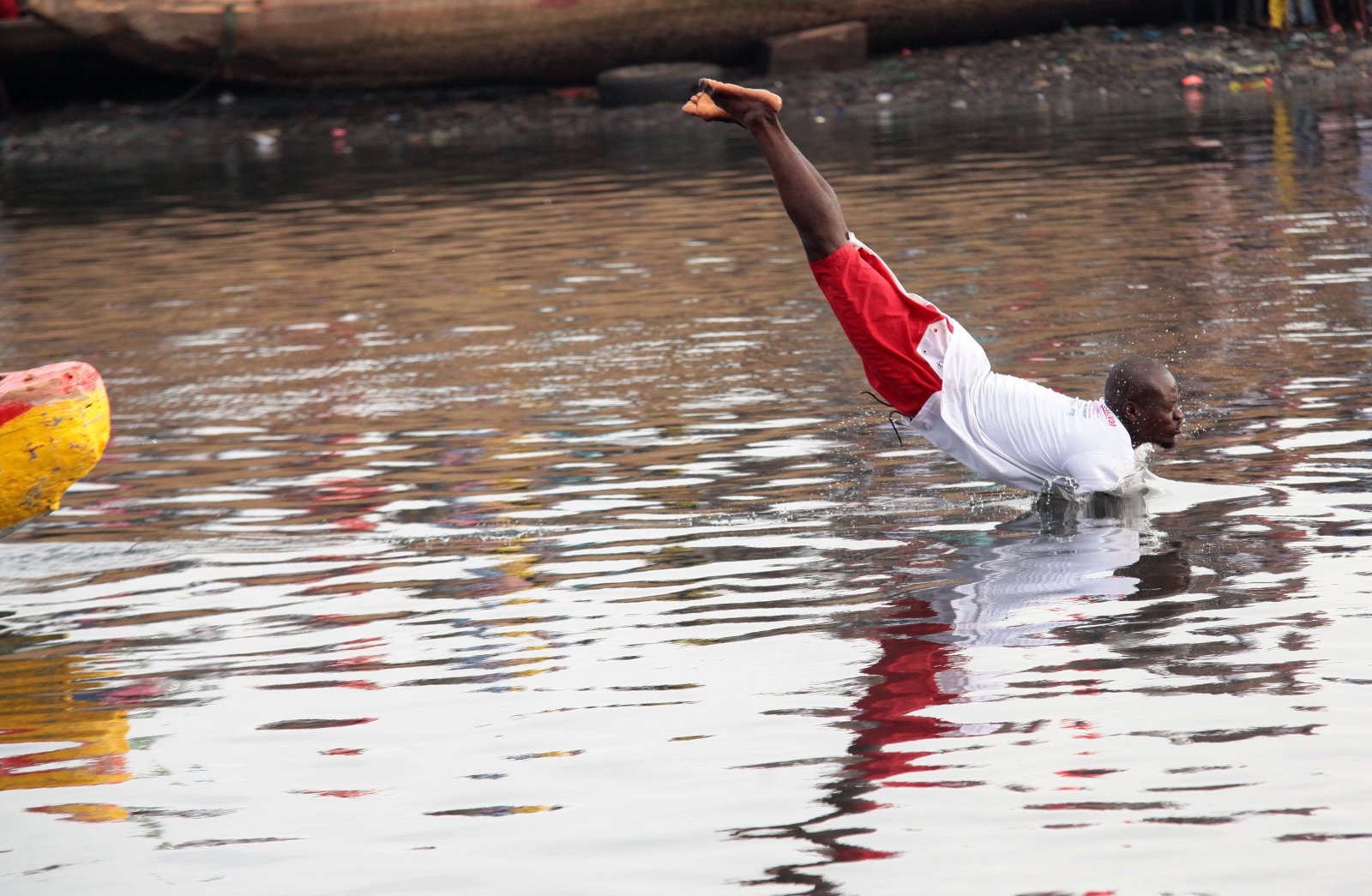 Mężczyzna rzuca się do wody w trakcie festiwalu Edina Bakatue, Ghana.