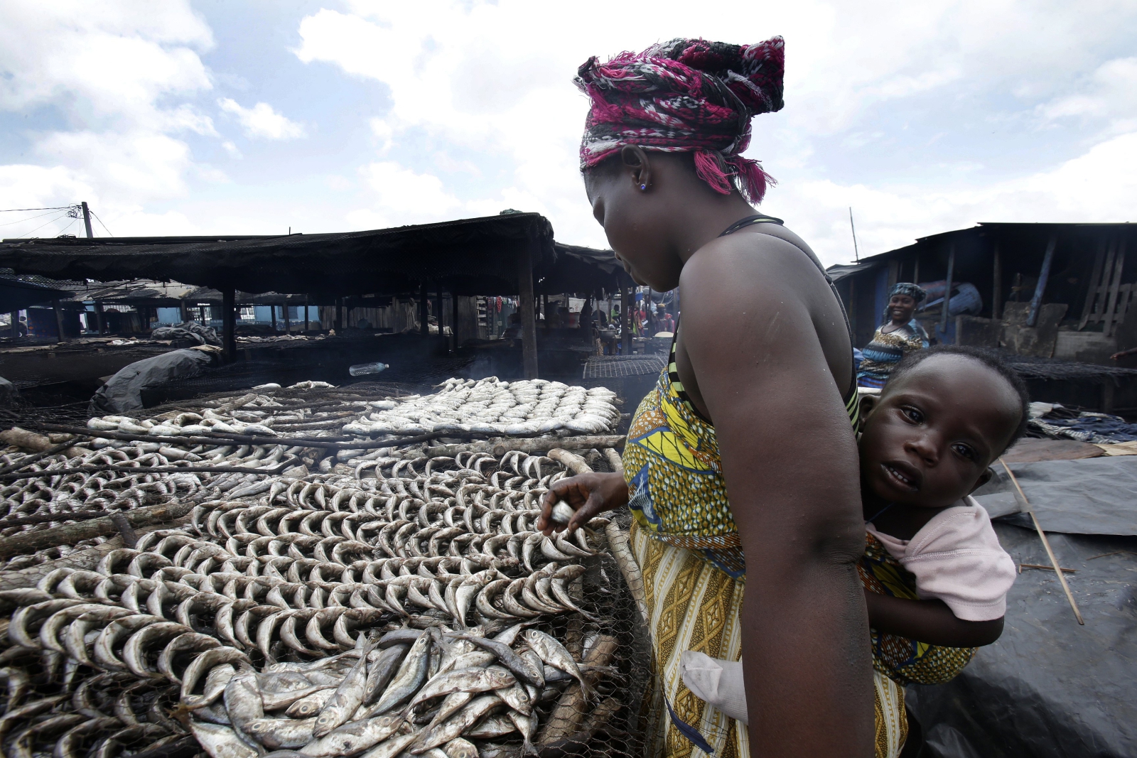 Kobieta pracuje na targu rybnym, Wybrzeże Kości Słoniowej.