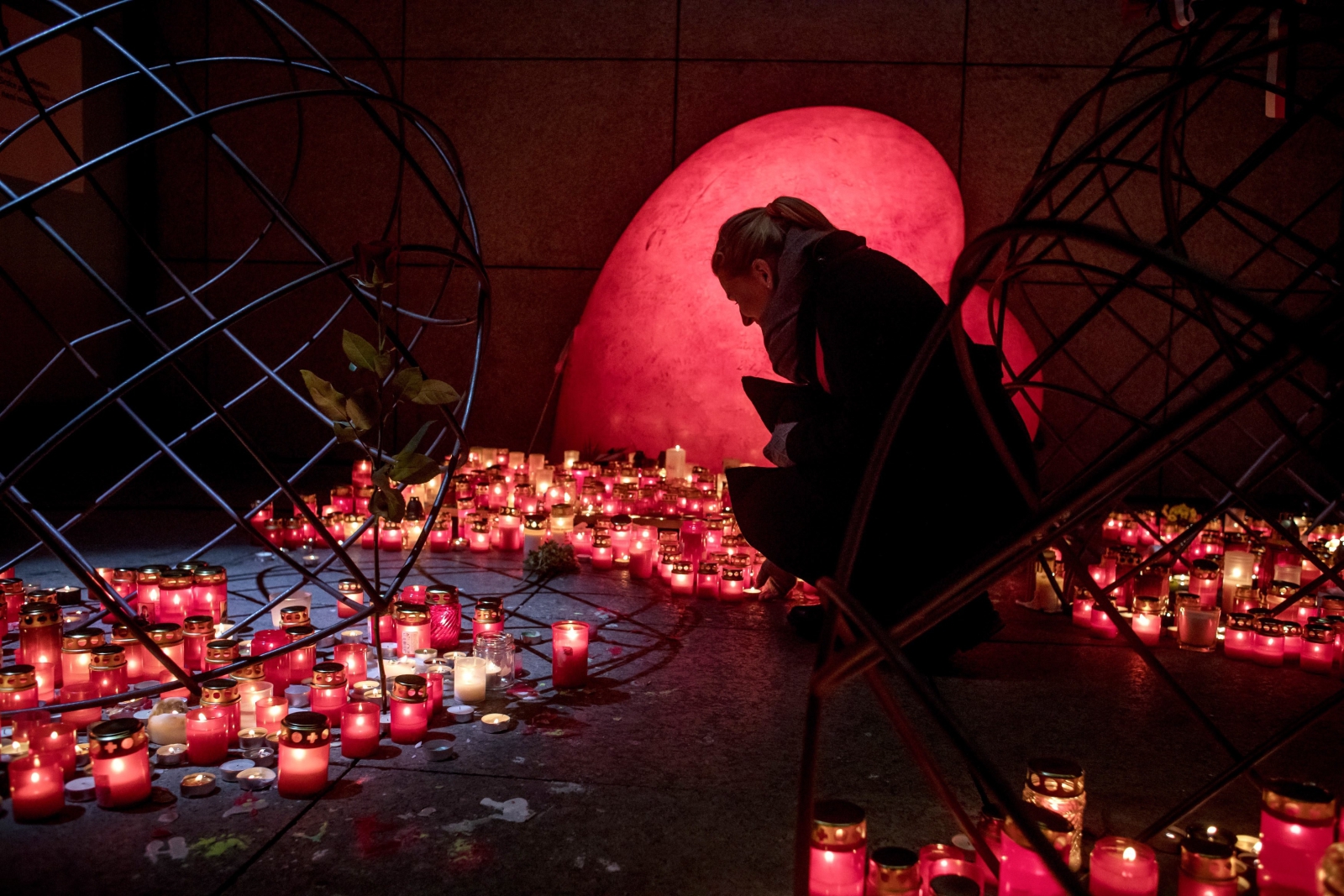 Kobieta zapala świeczkę wspominając Vaclava Havla w 28 rocznicę aksamitnej rewolucji, Praga, Czechy.