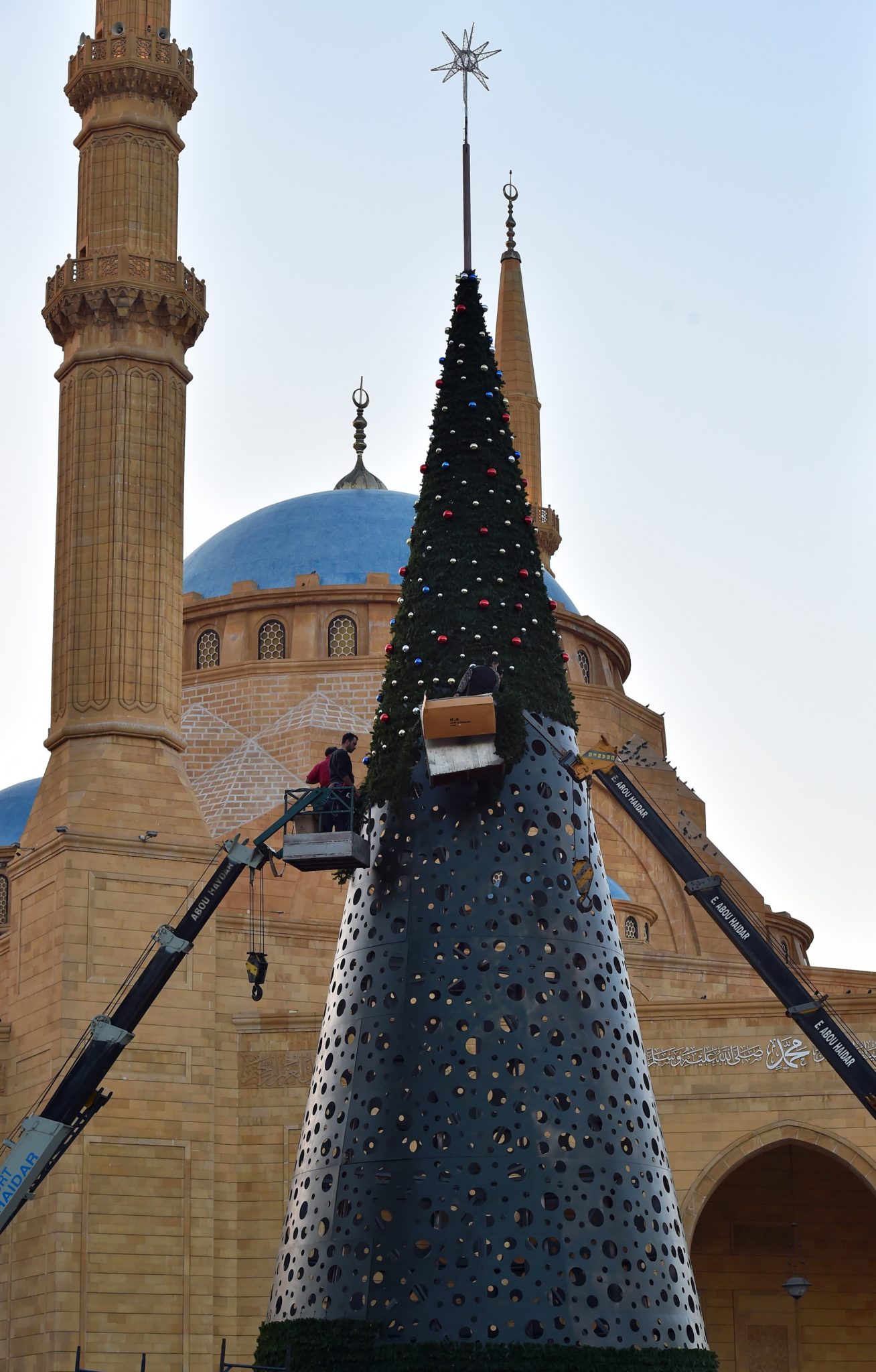 Pracownicy na żurawiu zdobią gigantyczną choinkę wzniesioną przed meczetem Muhammada al-Amine, w Bejrucie w Libanie, fot: Wael Hamzeh, PAP/EPA