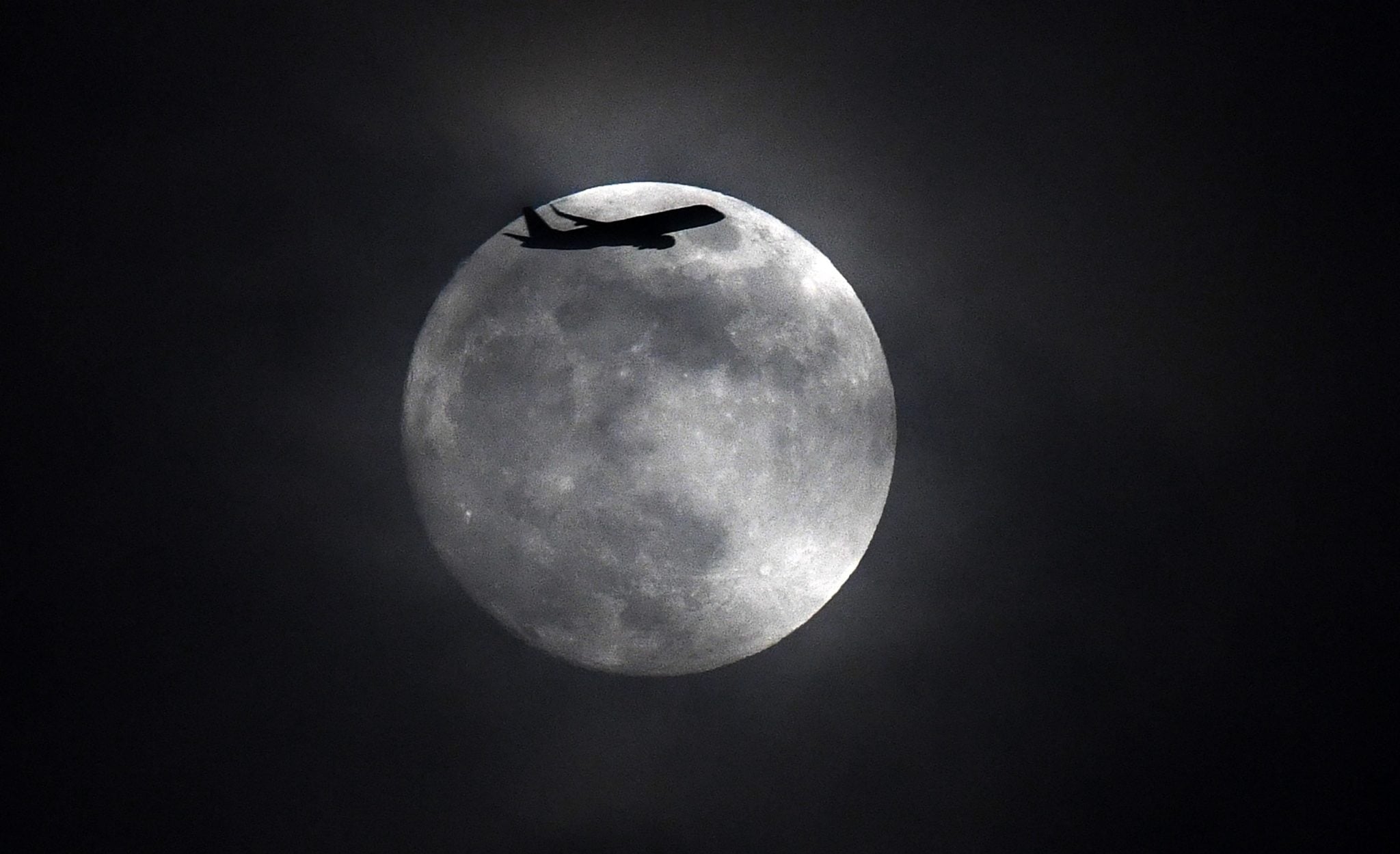 Wlk. Brytania: Samolot leci nad Londynem, na tle księżyca w pełni, fot: Facundo Arrizabalaga, PAP/EPA 