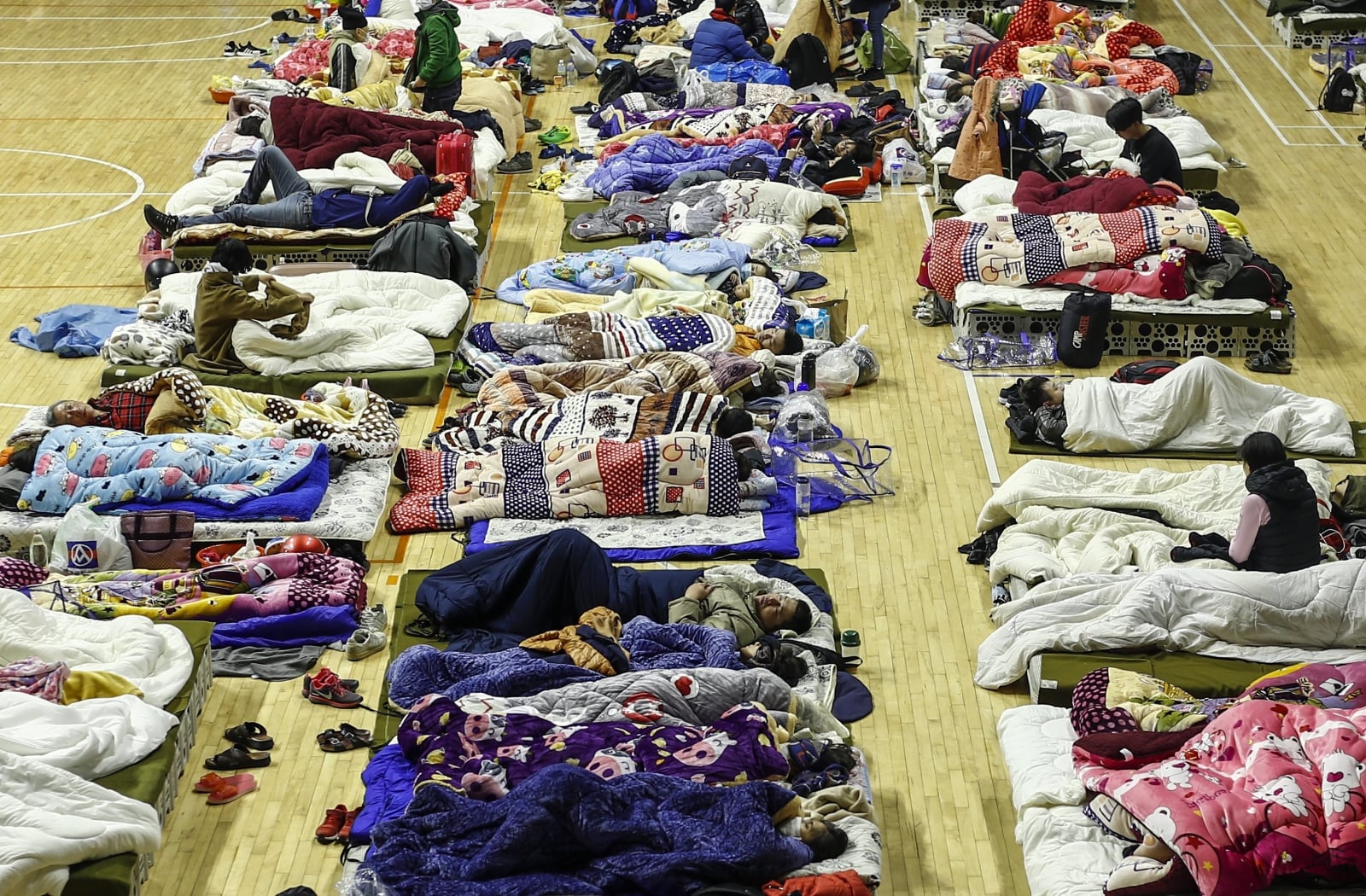 epa06503348 Displaced earthquake affected residents rest inside a gymnasium turned into a temporary shelter in Hualien, Taiwan, 08 February 2018. According to local media reports, at least six people were killed and more than 200 injured in the 6.4 magnitude earthquake on 06 February that severely damaged and partially collapsed at least four buildings. Rescue operations are underway as 76 people are believed to be missing in the rubble. Another 5.7 magnitude earthquake was detected on 07 February 2018 as aftershocks continue to hit Taiwan.  EPA/RITCHIE B. TONGO 
Dostawca: PAP/EPA.