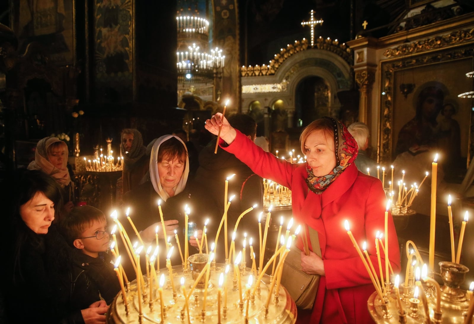 Wierni prawosławni zapalają świece w czasie Mszy wigilijnej, Kijów, Ukraina.