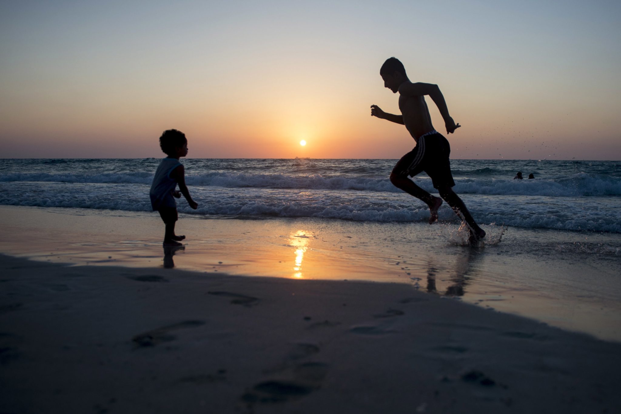 Egipt, Aleksandria. Egipski chłopiec biegnie na plaży o zachodzie słońca na północnym wybrzeżu Morza Śródziemnego, fot. Mohamed Hossam, PAP/EPA 