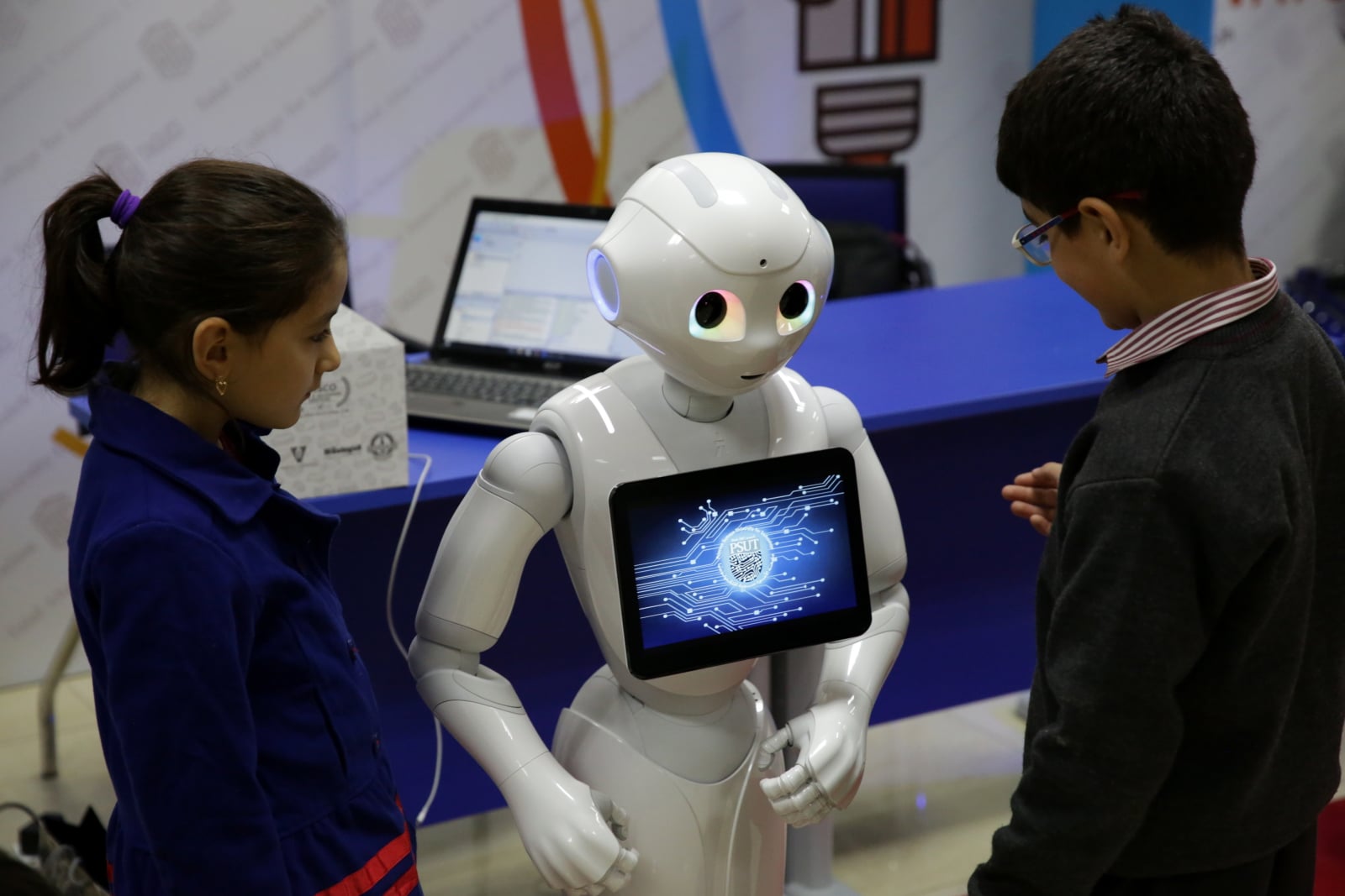 Dzieci wchodzą w interakcje z robotem Pepper, podczas wystawy Jordanian Robot 2018, w Ammanie, Jordania.