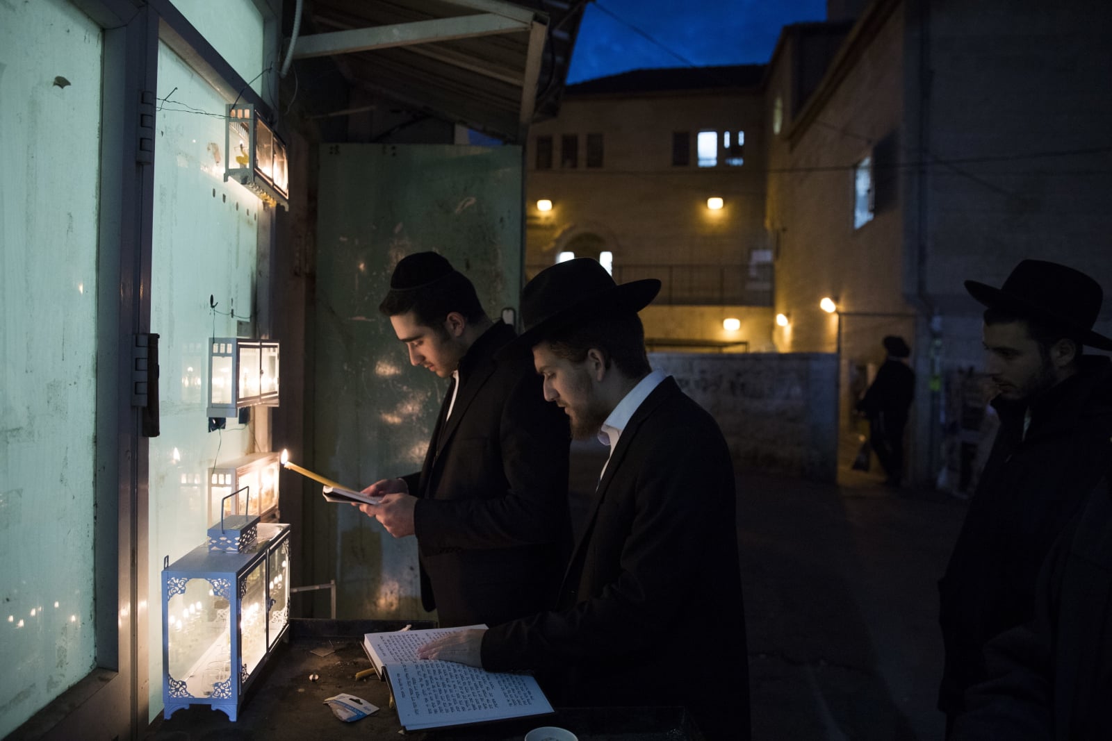 epa07210538 An Ultra-Orthodox Jew lights a Hanukkah candle outside his house during the Jewish holiday of Hanukkah in the Mea Shearim neighbourhood of Jerusalem, Israel, 05 December 2018. Hanukkah, also known as the 'Festival of Lights', is one of the most important Jewish holidays and is celebrated by Jews worldwide. Hanukkah began in the evening of 02 December and ends in the evening of 10 December.  EPA/ABIR SULTAN 
Dostawca: PAP/EPA.