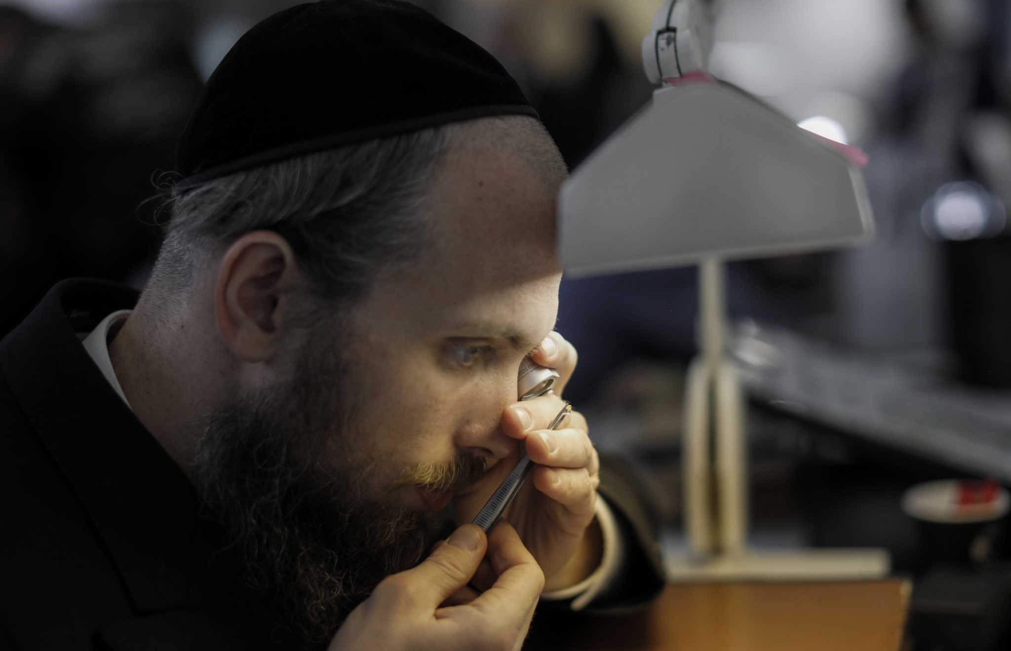 Ultra-ortodoksyjny żydowski kupiec sprawdza jakość diamentu podczas Międzynarodowego Tygodnia Diamentów Izraela w mieście Ramat Gan niedaleko Tel Awiwu, fot. Atef Safadi, PAP/EPA