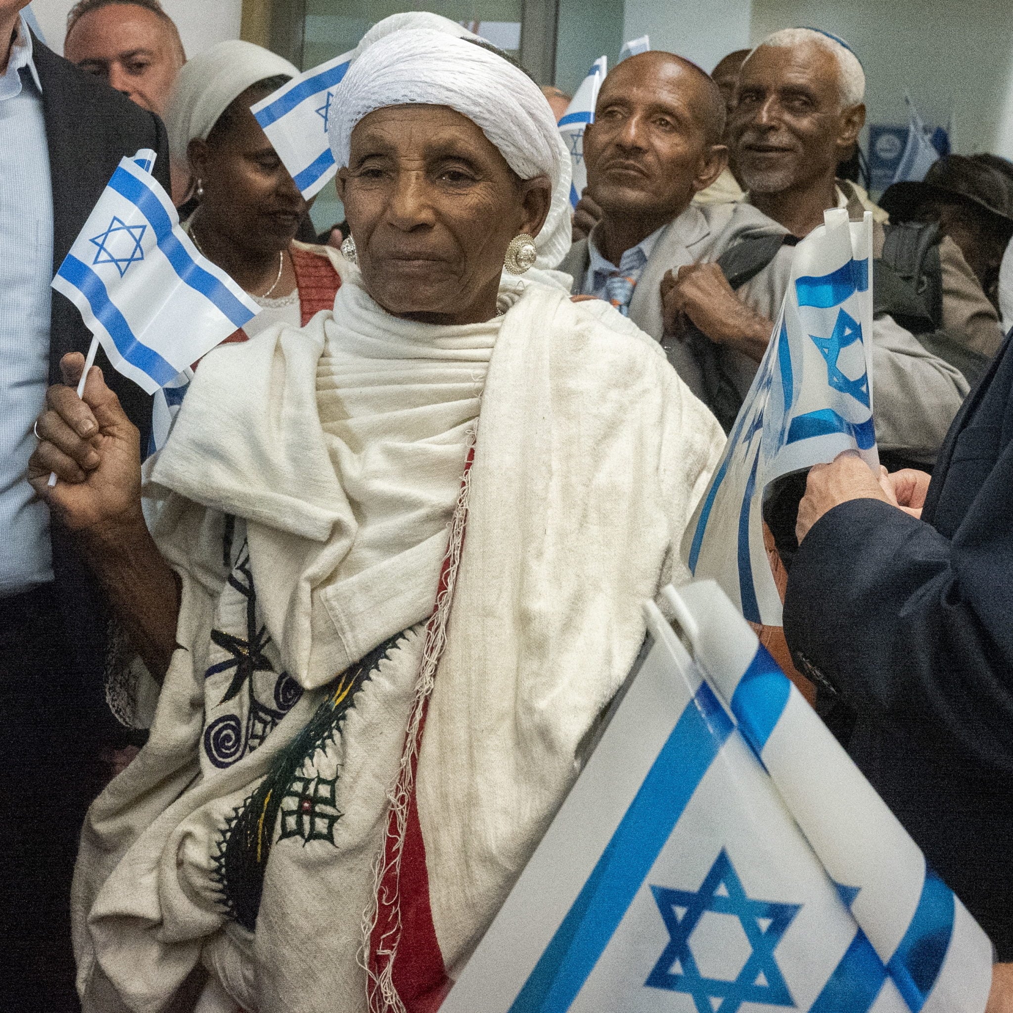 Izrael: etiopscy imigranci odbierają izraelskie flagi po przybyciu do hali przylotów na lotnisku Ben Gurion poza Tel Avivem. Około 80 imigrantów z Etiopii przybyło do Izraela, dołączy do etiopskich imigrantów, którzy są już w Izraelu, fot. JIM HOLLANDER, PAP/EPA