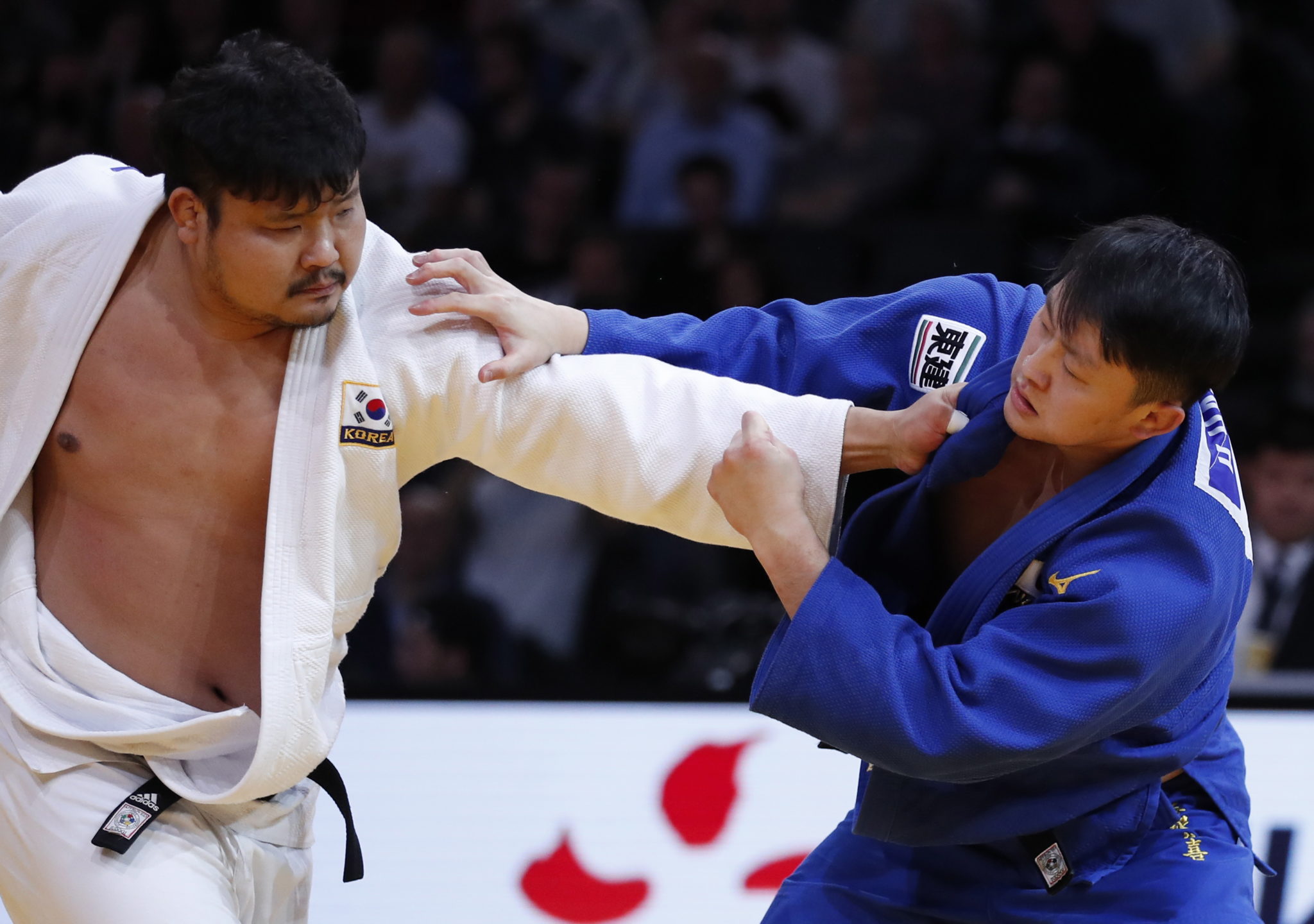 Paryż: Sungmi Kim z Korei (strój biały) w akcji z Hisayoshi Harasawą z Japonii (niebieski) podczas męskiego finału judo (waga 100 kg plus) podczas turnieju Paris Grand Slam judo, fot.IAN LANGSDON, PAP/EPA