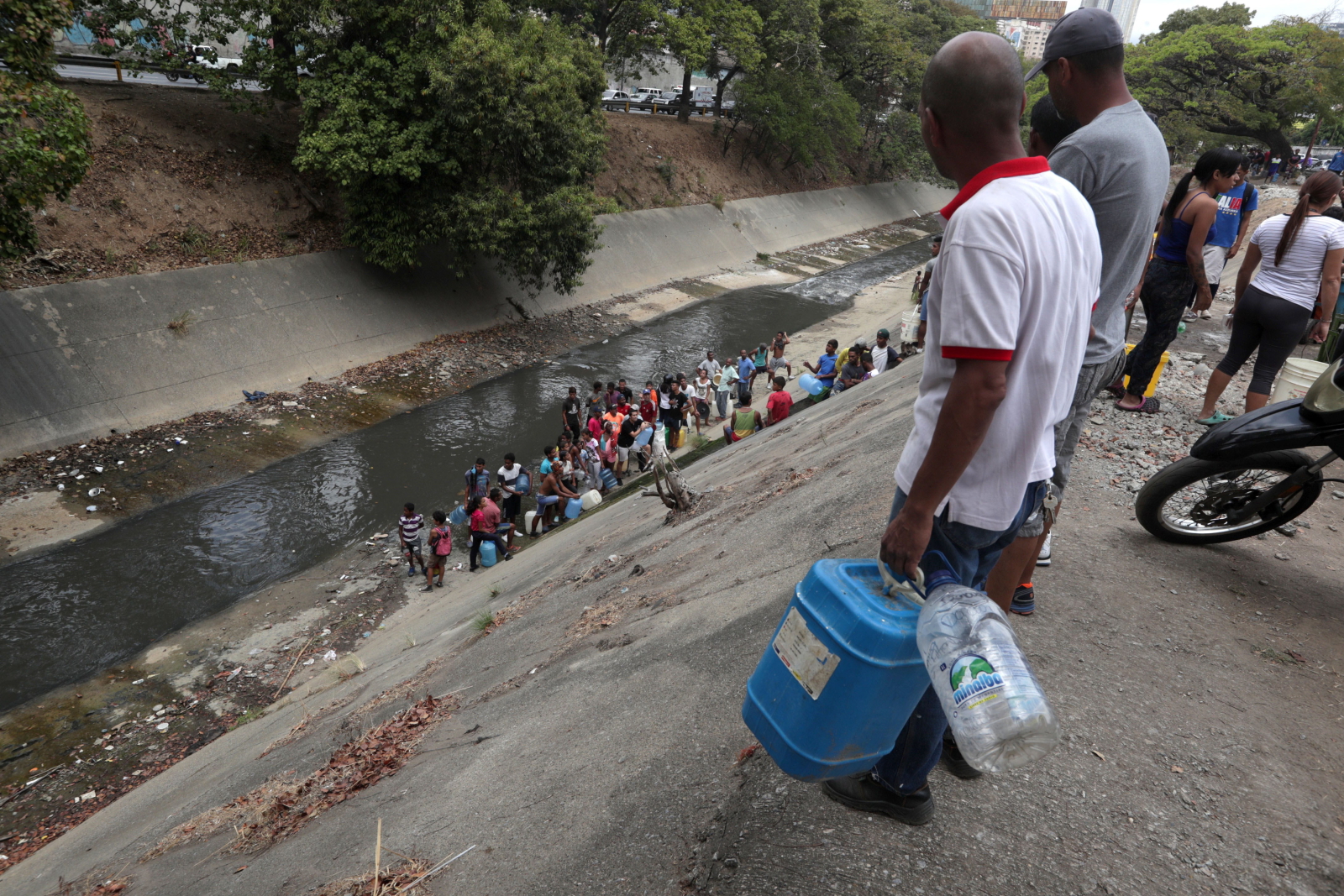 Ludzie w kolejce do zbierania wody na autostradzie Francisco Fajardo, w Caracas, Wenezuela