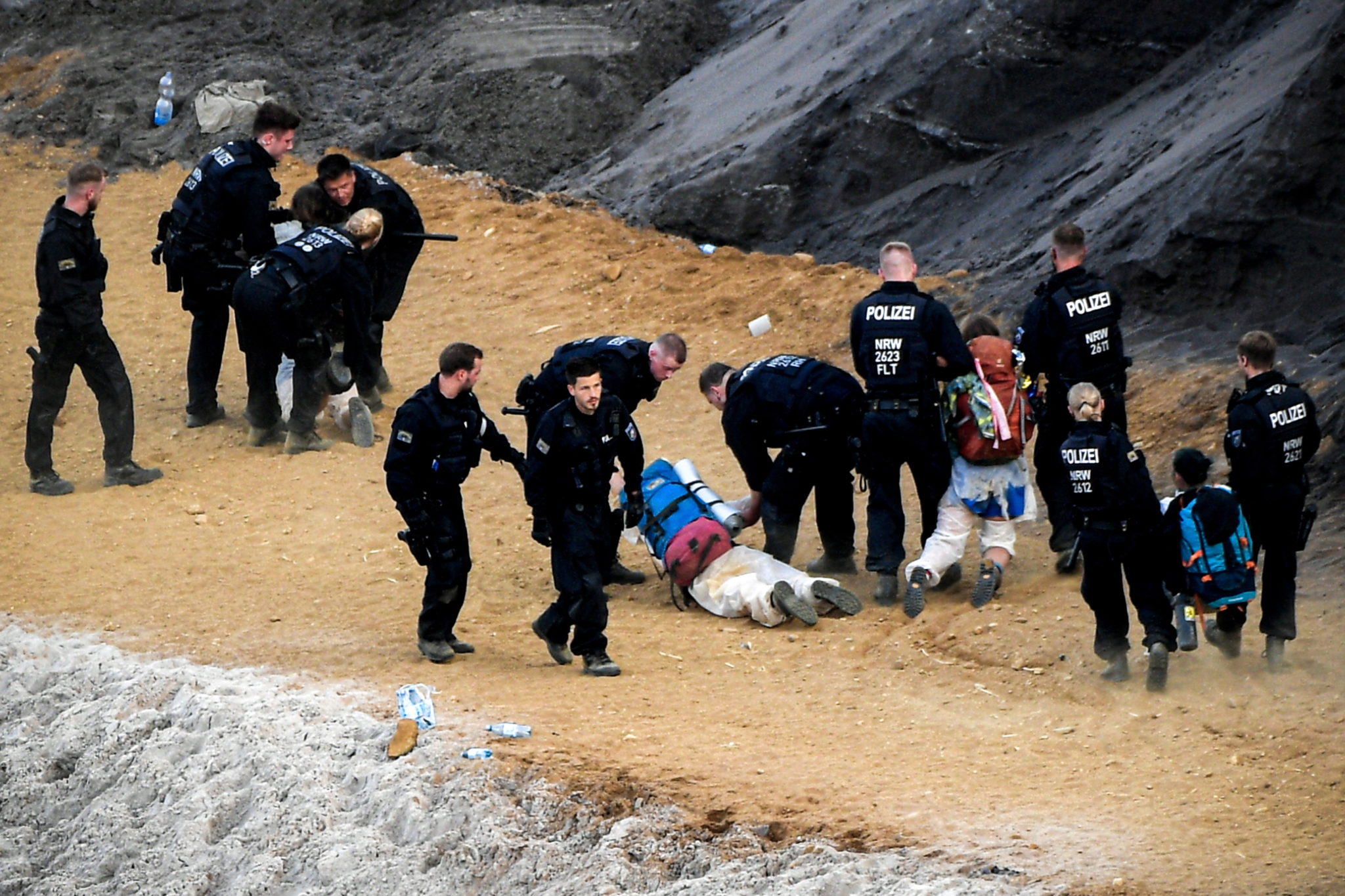 epa07667113 Activists taking part in the 'Ende Gelaende' protest initiative face a police cordon in a pit in the Rhenish coal mining area around Garzweiler in Jackerath, Germany, 22 June 2019. Several thousand protestors are expected at the 'Ende Gelaende' event from 19 through 24 June 2019.  EPA/SASCHA STEINBACH 
Dostawca: PAP/EPA.