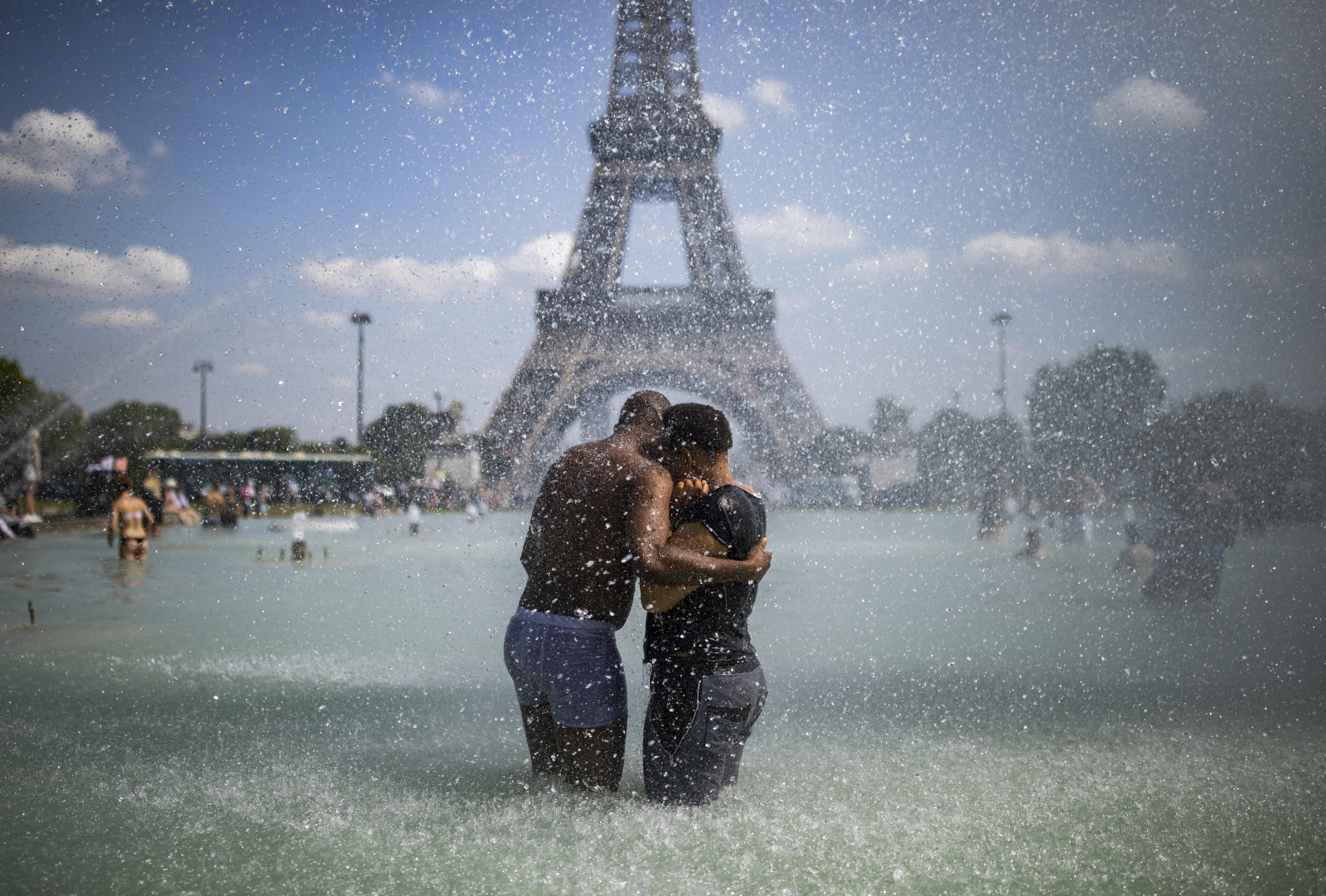 Upały we Francji. Para ochładza się w fontannie naprzeciwko wieży Eiffla. Fot. PAP/EPA/IAN LANGSDON