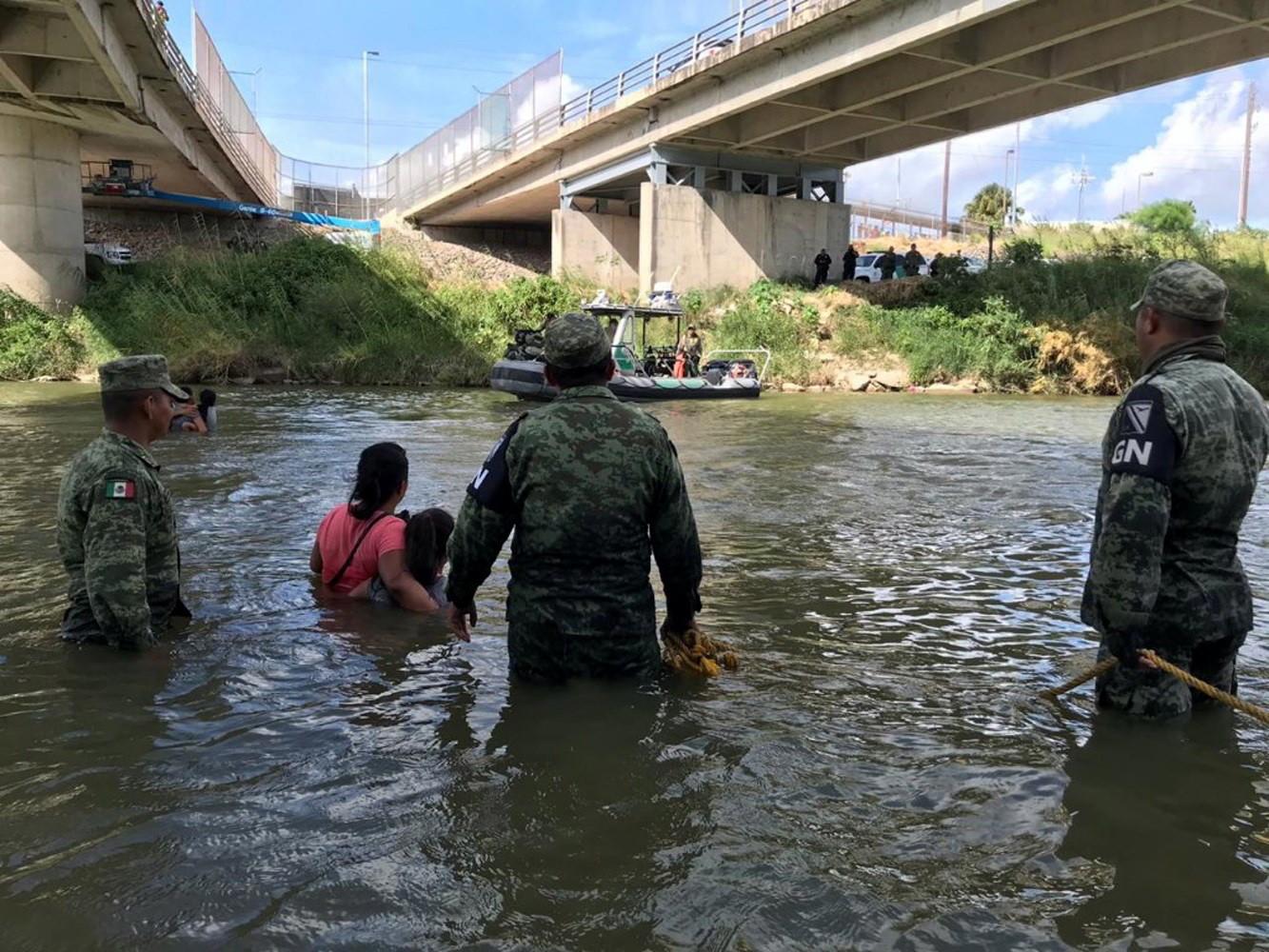 Meksyk: Gwardia Narodowa przekonują gwatemalską rodzinę, by zrezygnowała z przekraczania Rio Bravo (rzeki Rio Grande) przy moście granicznym Puente Nuevo w Tamaulipas, fot. Marco Rodriguez, PAP/EPA.