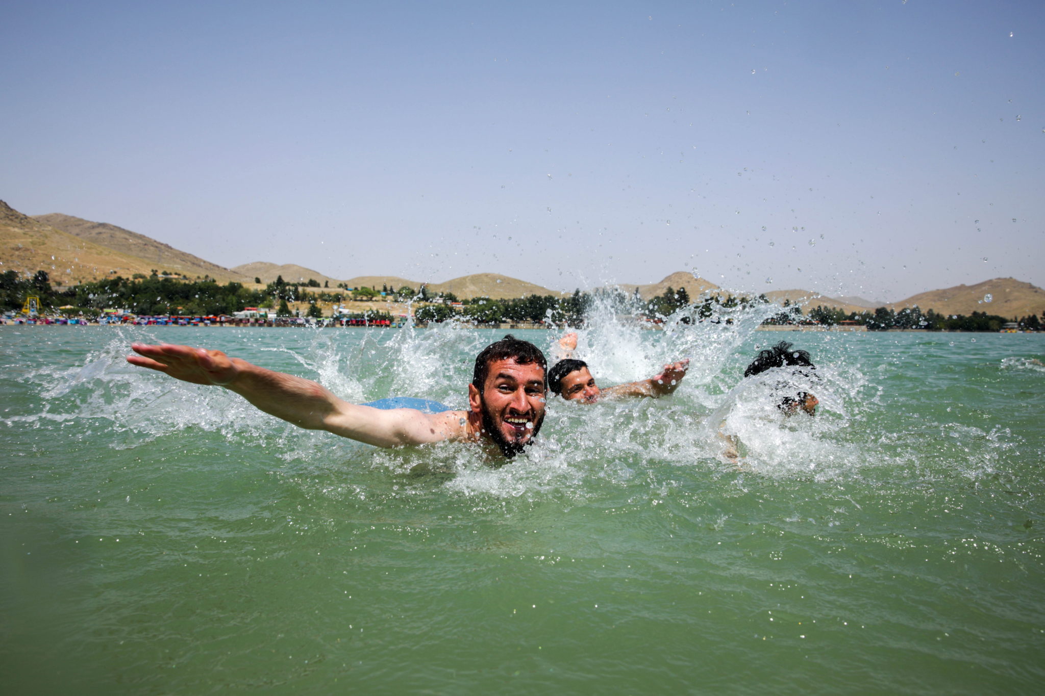 Afgańczycy pływają w jeziorze Qargha, aby ochłodzić się w czasie upału w Kabulu, upały są tak wysokie, że zanotowano z tego powodu także ofiary śmiertelne, fot. HEDAYATULLAH AMID, PAP/EPA.