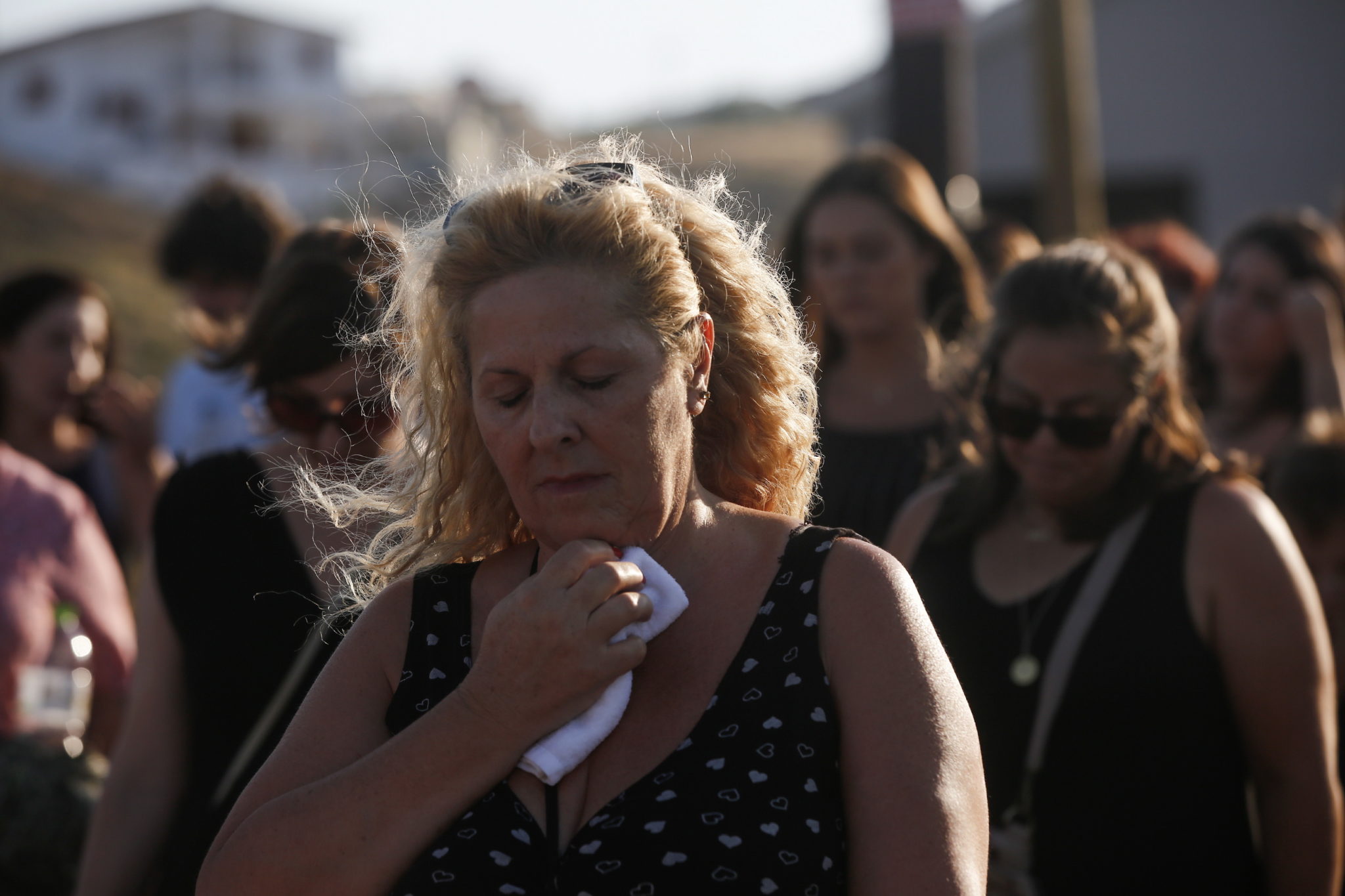 Ludzie i krewni ofiar idą w kierunku nadmorskiej wioski Mati, aby uczestniczyć w nabożeństwie żałobnym rok po śmiertelnym pożarze lasu, który zabił 102 osoby w Neos Voutzas, na północny zachód od Aten