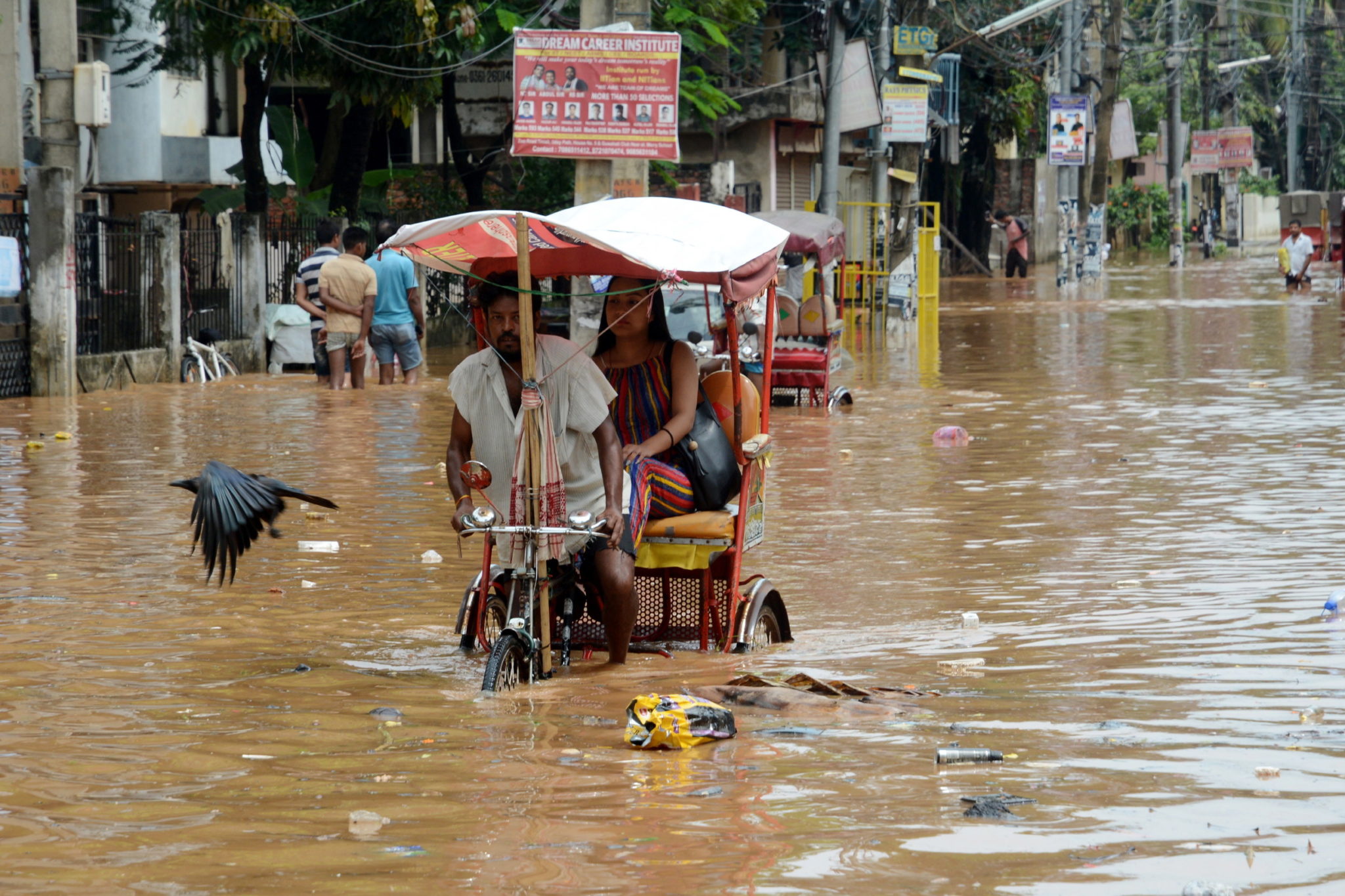 Indie: właściciel rikszy przemierza zalaną po monsunowym deszczu ulicę w Guwahati. Fot. EPA/STR 