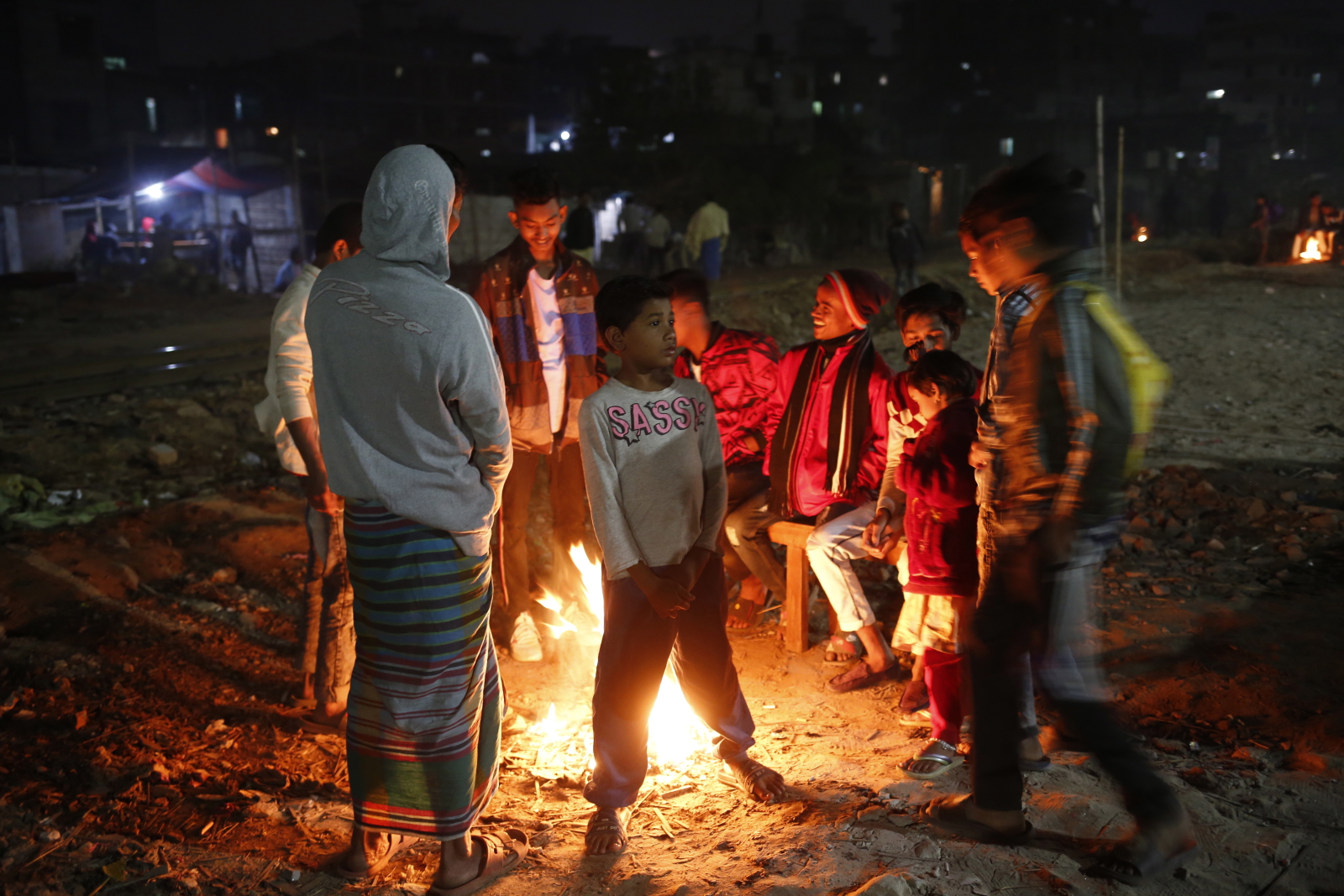 Dzieci na wysypisku śmieci w Bangladeszu próbują się ogrzać w zimna noc  EPA/MONIRUL ALAM 