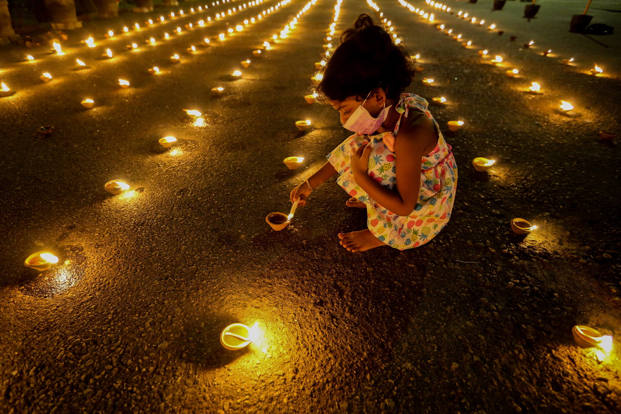 Sri Lanka:  dziewczynka zapala świecę na pamiętkę dnia narodzin buddy. fot. EPA/CHAMILA KARUNARATHNE