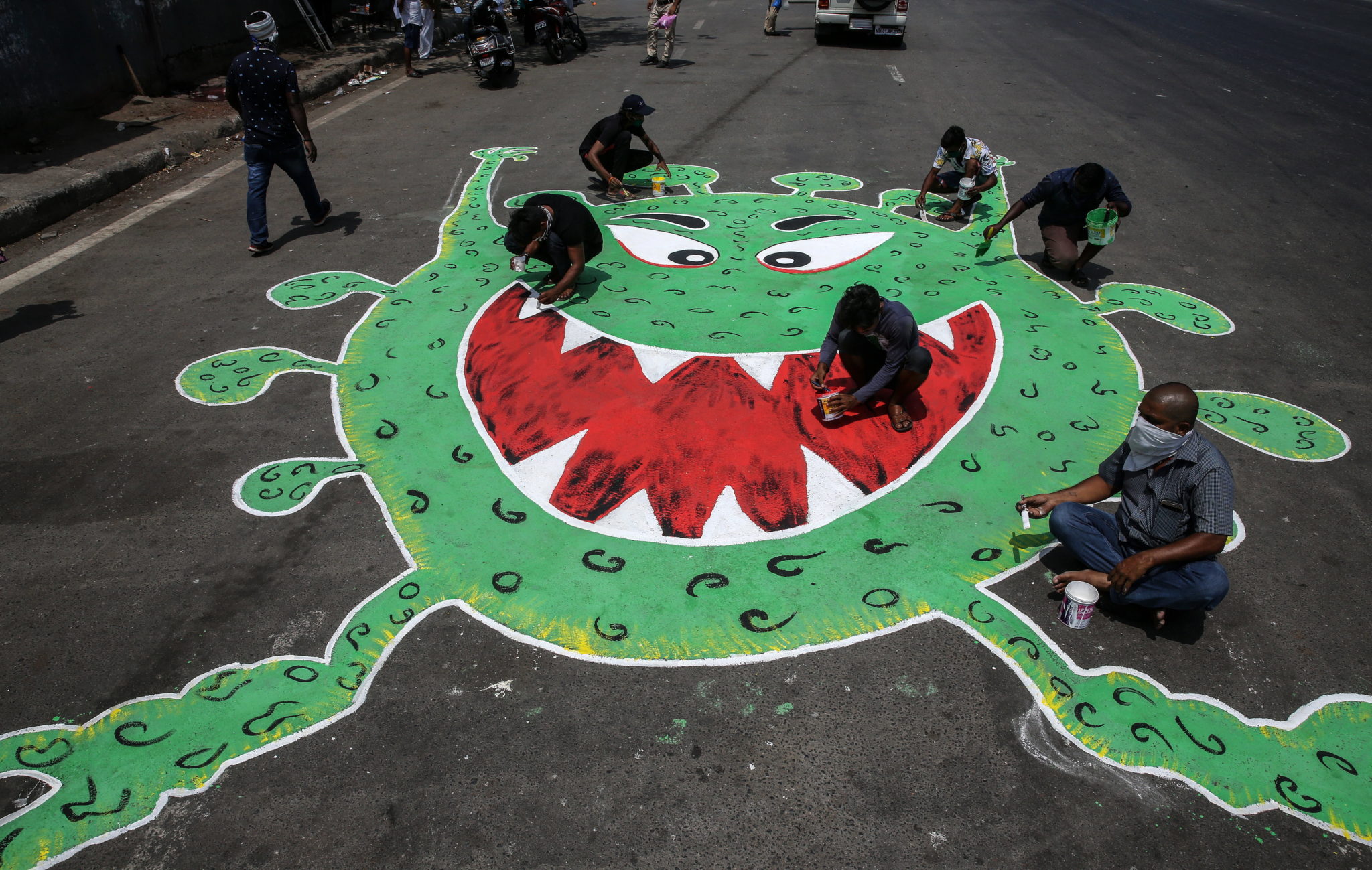 Indie: miejscowi artyści malują korona-grafitti. fot. EPA/DIVYAKANT SOLANKI
