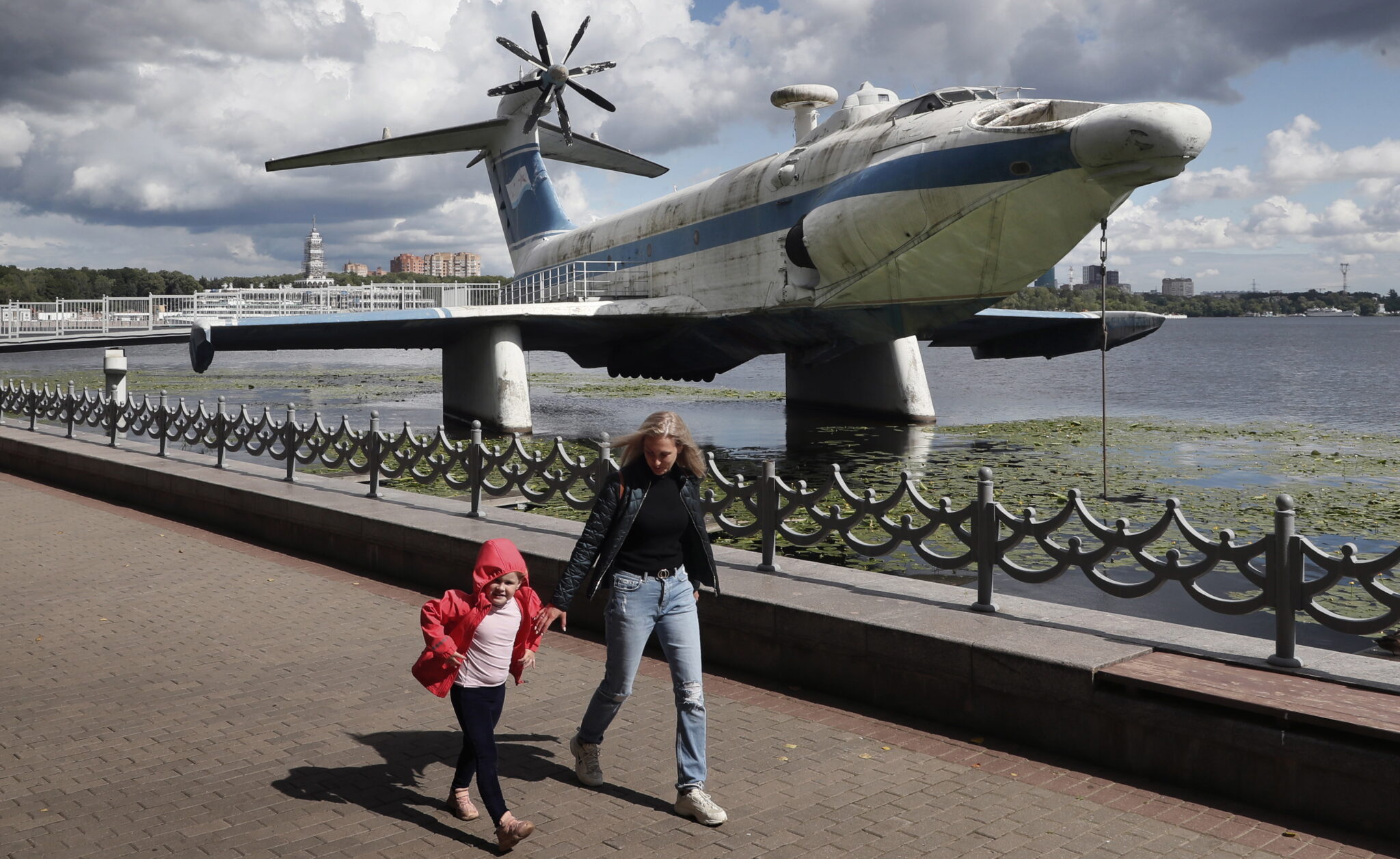 Życie codzienne w Moskwie. Spacer wzdłuż Moskwy, w tle instalacja: radziecki samolot Ekranoplan A-90 Orlyonok. fot. EPA/MAXIM SHIPENKOV 
