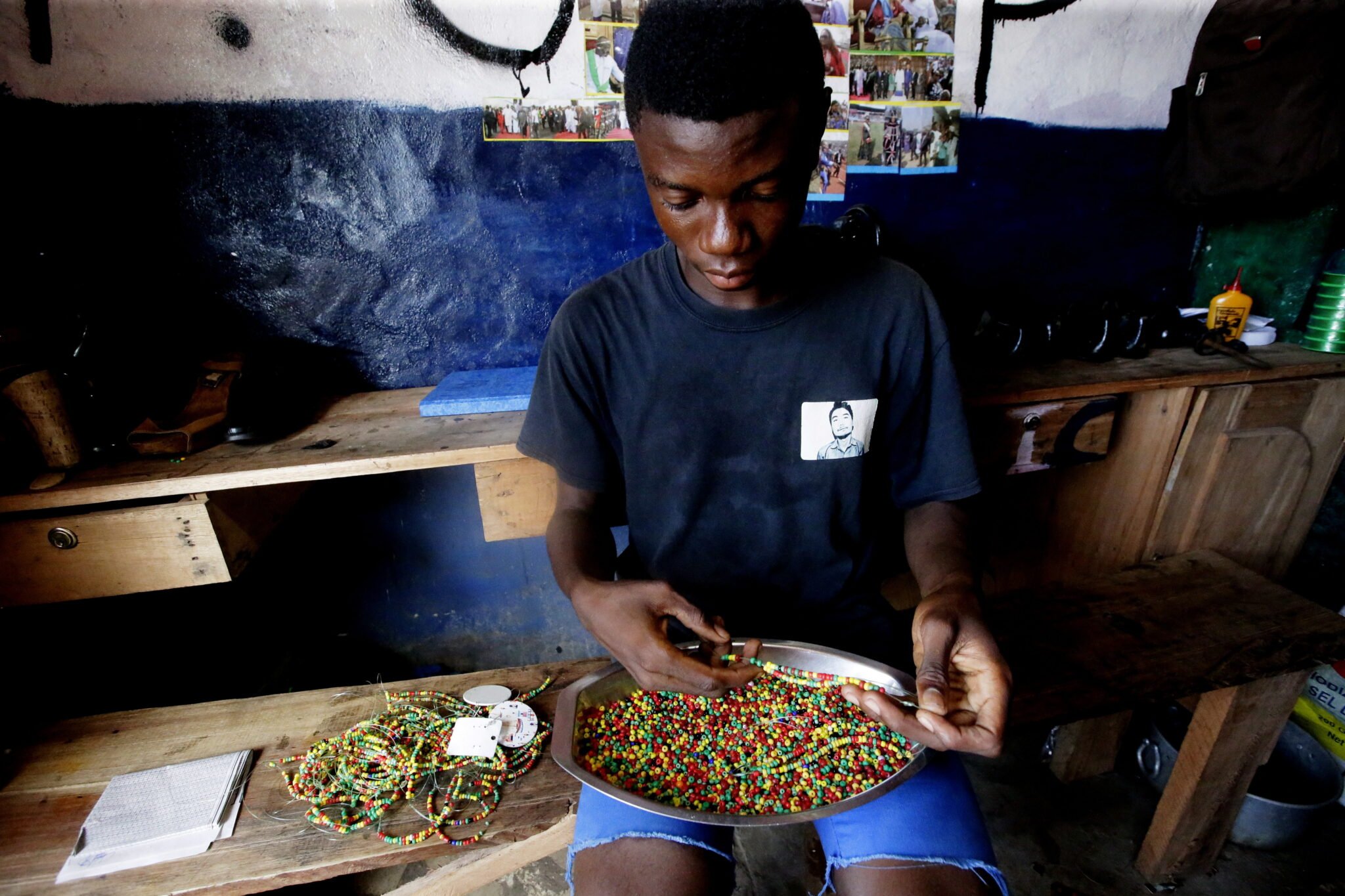  Liberia: Jones Farley, praktykant, przygotowuje naszyjniki i bransoletki w w sklepie w Monrowii, fot. EPA / AHMED JALLANZO 