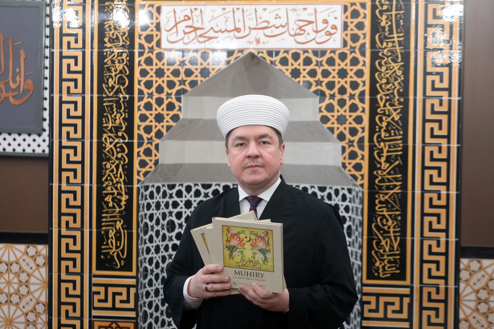 Mufti RP Tomasz Miśkiewicz prezentuje album „Muhiry. Tatarskie obrazy religijne” w Białymstoku. Ponad 50 muhirów, czyli ozdobnych plansz lub tkanin, najczęściej z inskrypcjami z Koranu, pochodzących z meczetów i domów modlitw polskich wyznawców islamu, zbiorów muzealnych i kolekcji prywatnych, znalazło się w albumie wydanym przez Muzułmański Związek Religijny w RP. fot. PAP/Artur Reszko