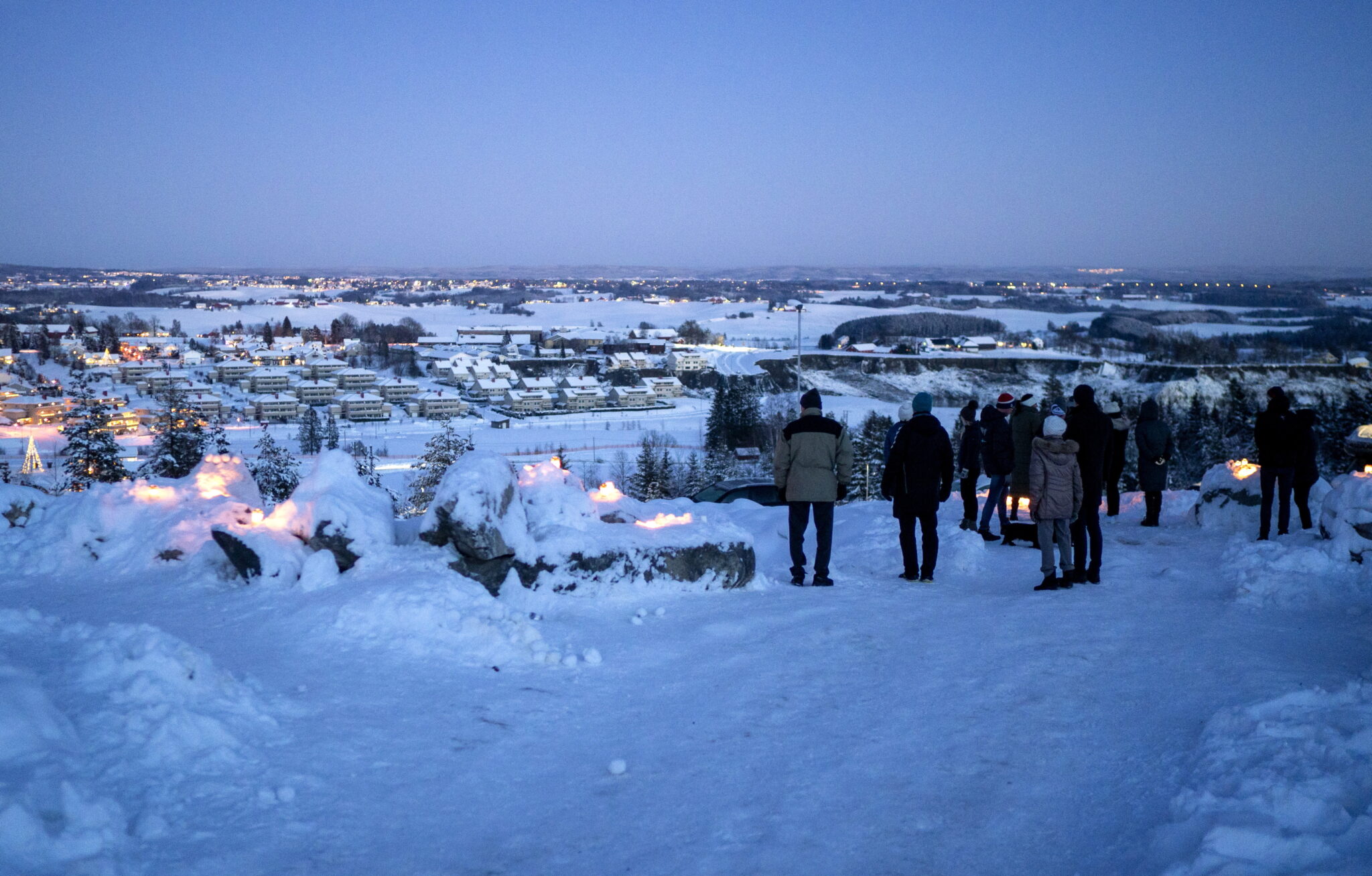Ludzie zapalają świece w rejonie osuwiska w Ask, Norwegia, fot. EPA