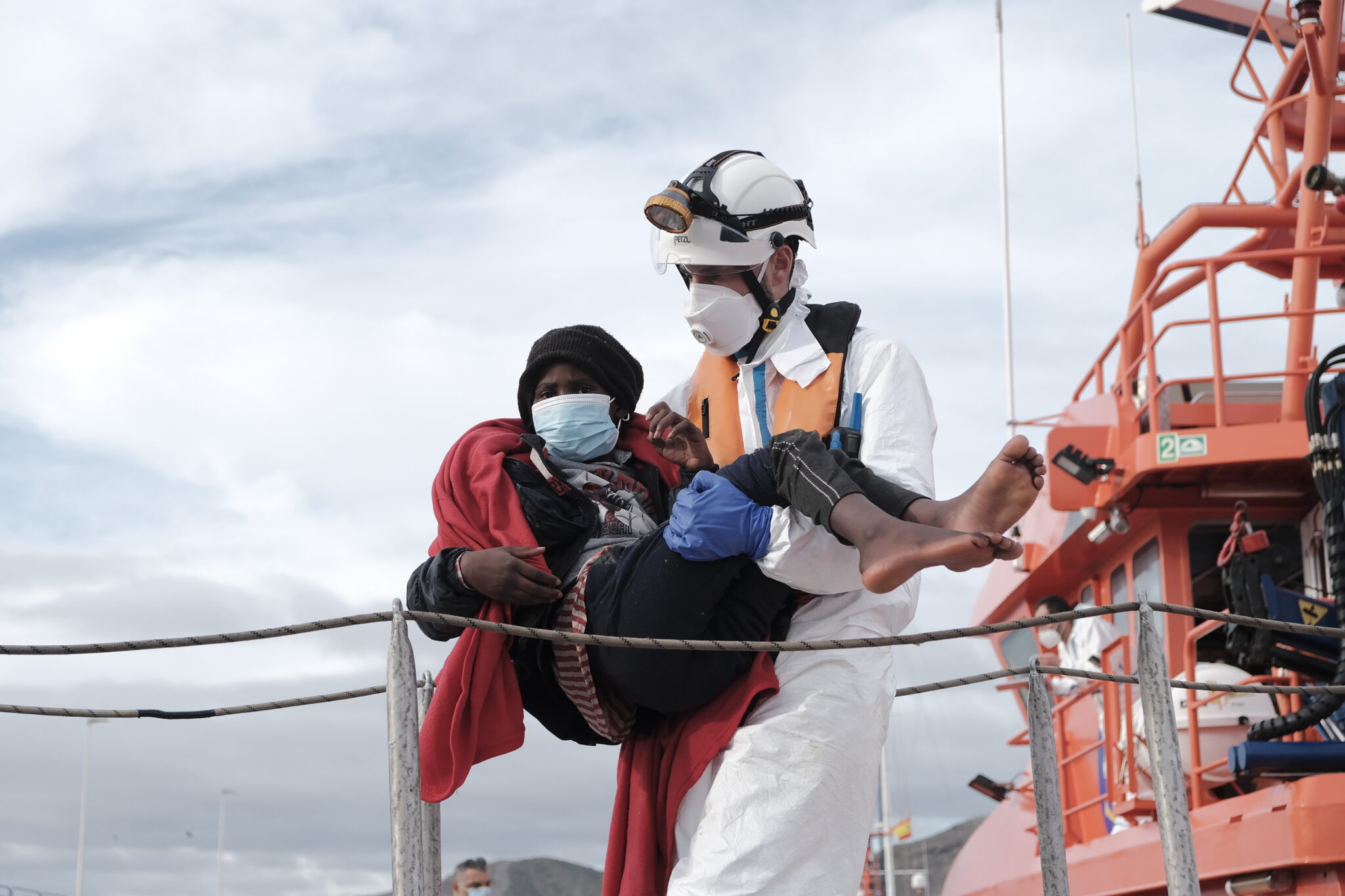 Pracownicy Czerwonego Krzyża pomagają uratowanym na wodzie migrantom, port Arguineguin na Gran Canarii, Hiszpania, fot. EPA / Ángel Medina G. 
