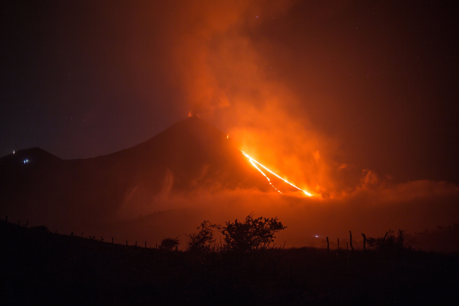 epa08997831 A general view of the Pacaya volcano expelling molten lava seen from the village of El Rodeo, in Escuintla, Guatemala, 08 February 2021. The volcano has increased its activity in recent days with explosions and rivers of lava on its slopes.  EPA/Esteban Biba 
Dostawca: PAP/EPA.