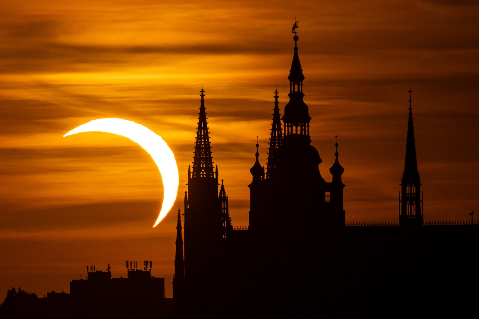epa13164402 Prague Castle is silhouetted against a partial solar eclipse in Prague, Czech Republic, 12 August 2026. A total solar eclipse will sweep across parts of Europe and the North Atlantic on 12 August, with the path of totality moving through Greenland, Iceland, Spain, and a small section of northeastern Portugal, while surrounding areas across Europe experience a partial solar eclipse, according to the European Space Agency (ESA). EPA/MARTIN DIVISEK Dostawca: PAP/EPA.